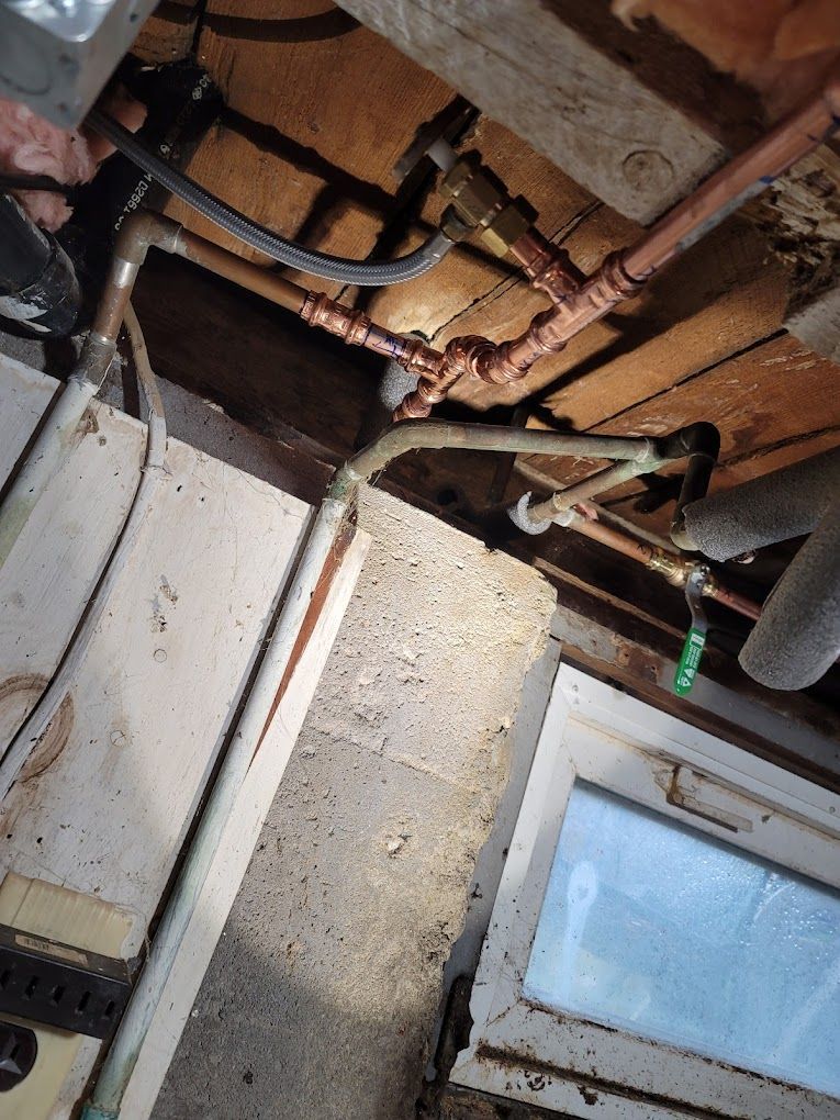 A bunch of pipes are hanging from the ceiling in a room.