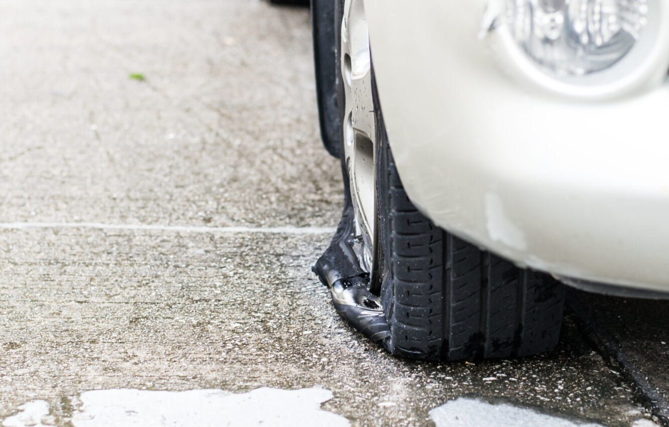 Flat Tire on a Car Parked on Wet Concrete — Wheel Alignment Centre in Braitling, NT