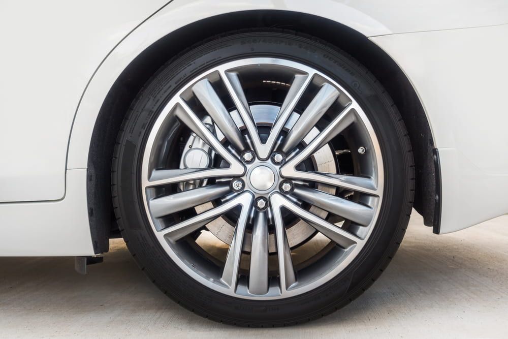 Close-up of a White Car's Wheel With a Silver Rim and Black Tire — Wheel Alignment Centre in Braitling, NT