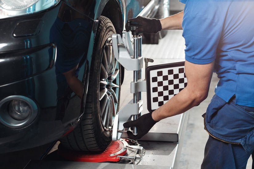 A Mechanic Using Wheel Alignment Equipment on a Car Tire — Wheel Alignment Centre in Braitling, NT