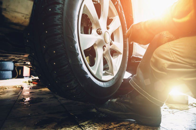 Mechanic Replacing a Tire in a Garage, Illuminated by Sunlight — Wheel Alignment Centre in Braitling, NT