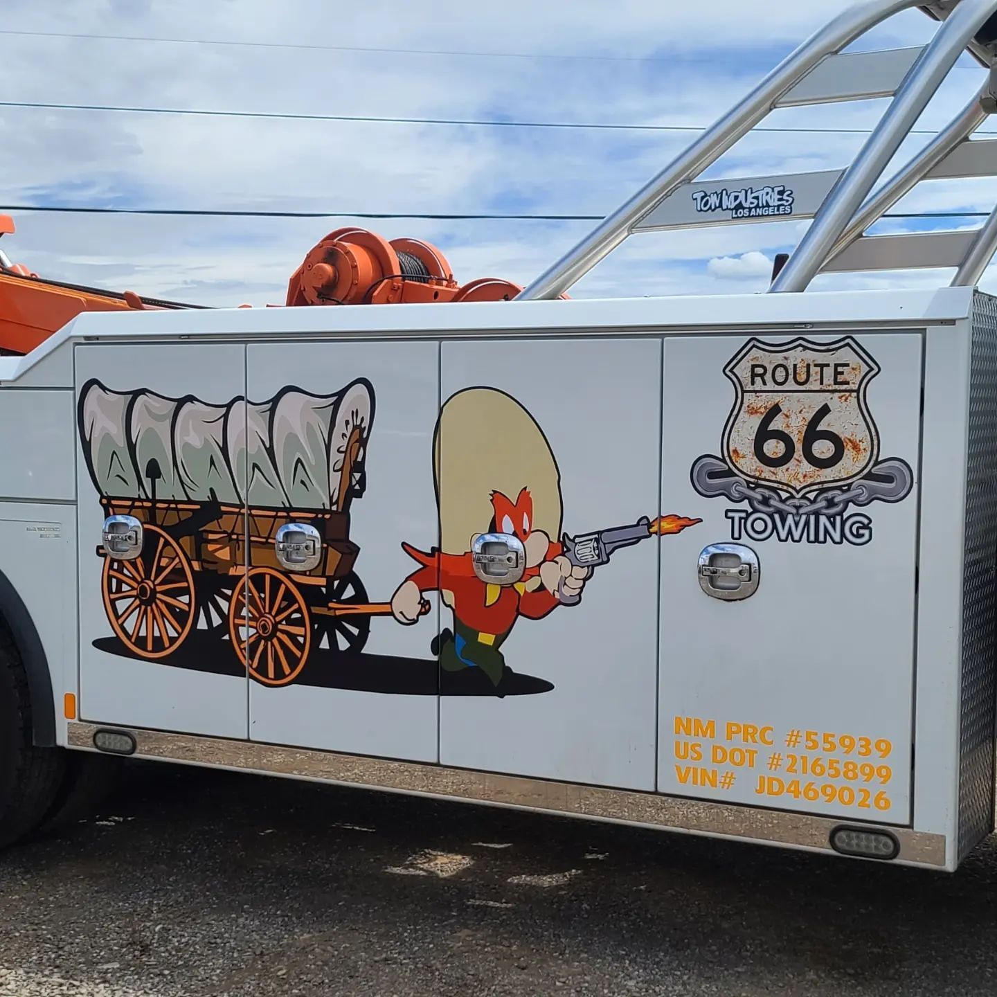 A route 66 towing truck has a picture of looney tunes on the side