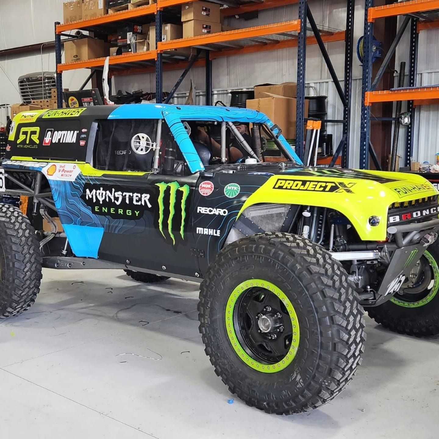 A monster energy truck is parked in a garage.