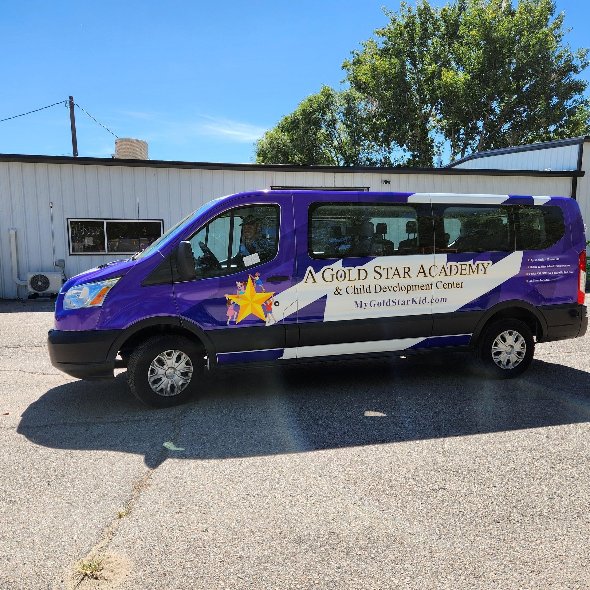 A purple van that says a gold star academy on it
