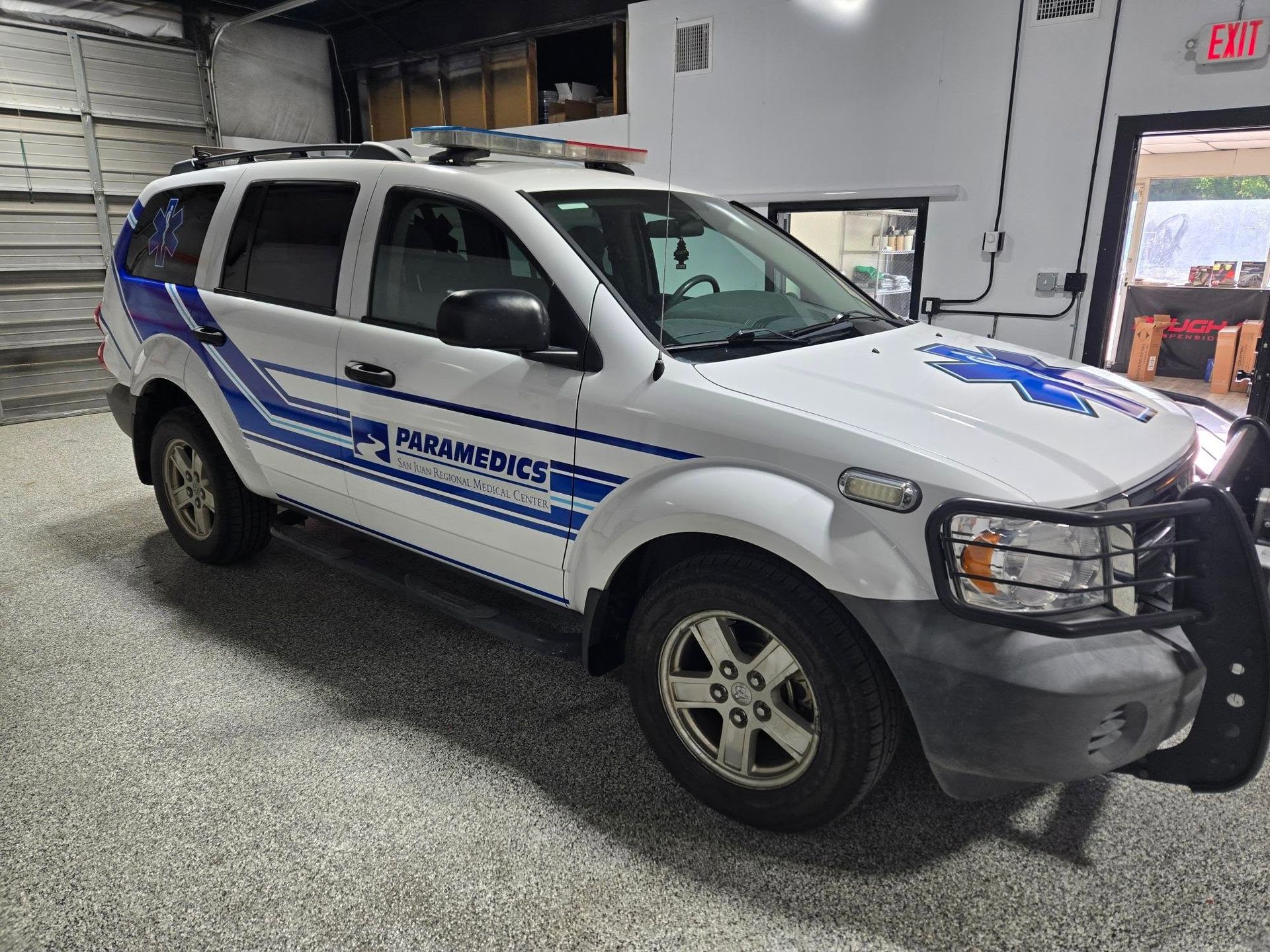 A white and blue ambulance is parked in a garage.
