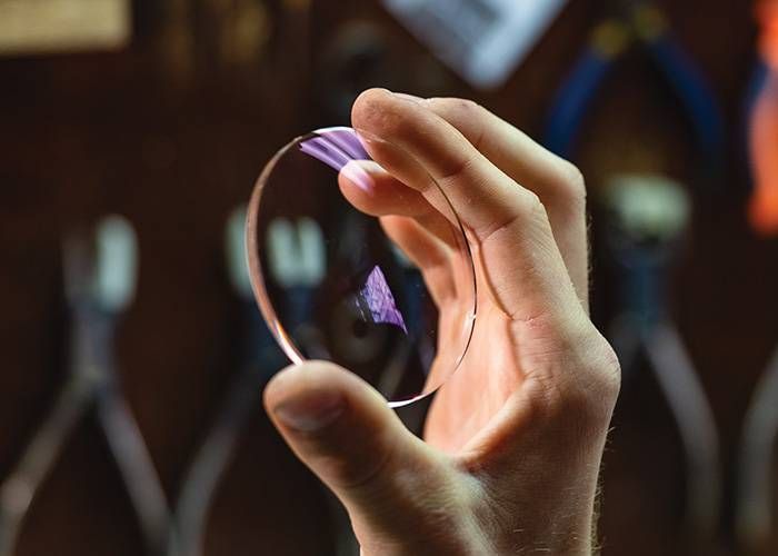 A man holding a Glass Lense — Optometrist in Wallsend, NSW