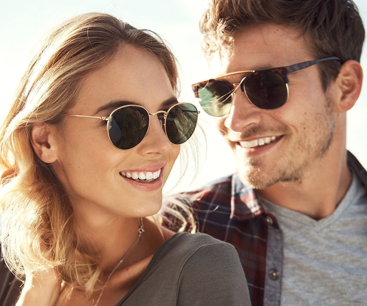 A men and women showing their prescription sunglasses— Optometrist in Wallsend, NSW