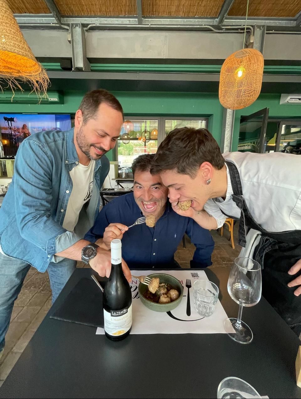 Chef che tiene in mano un piatto con un cannolo, guarnito con zucchero a velo e scorza d'arancia.