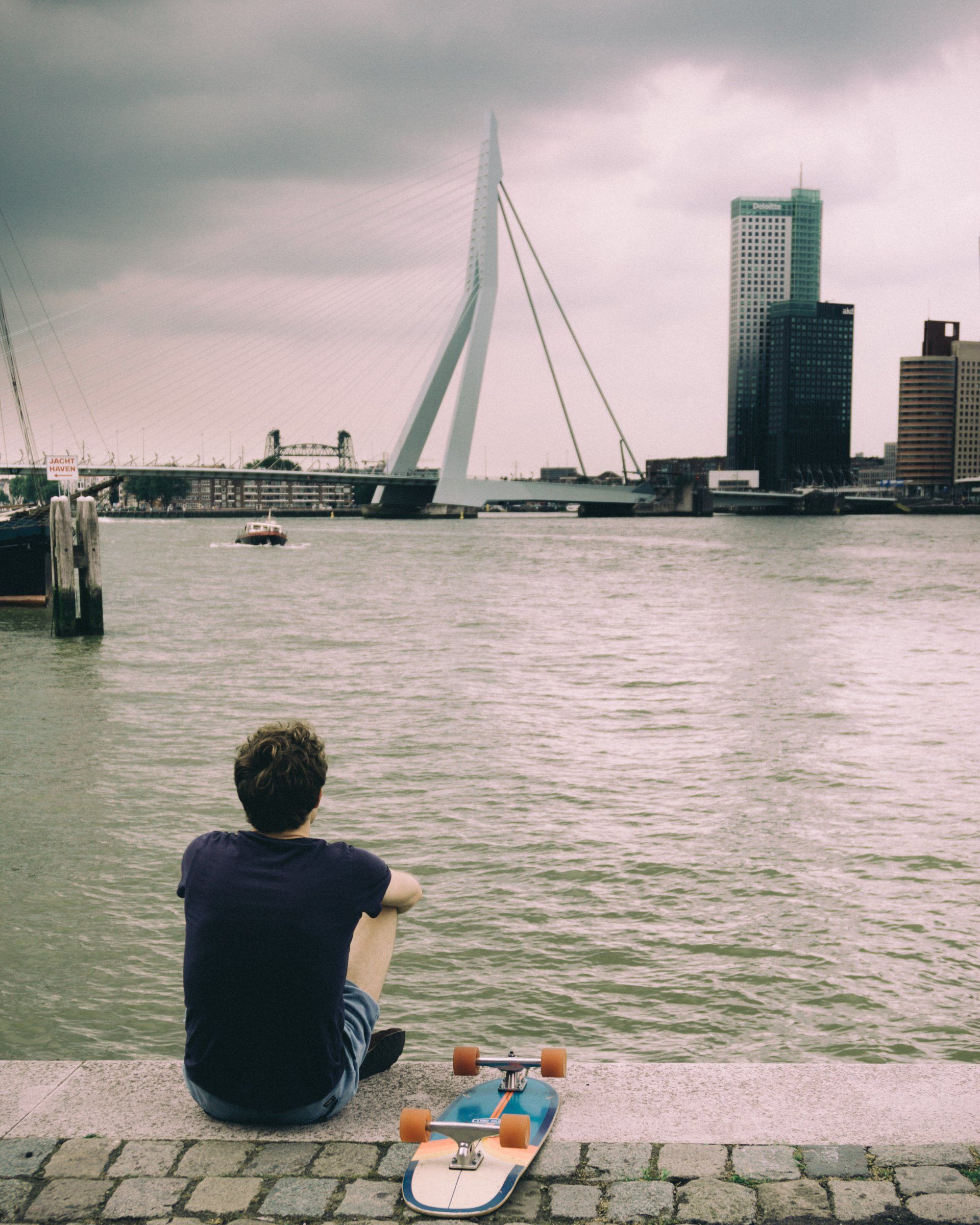 Street scene with a skater in Rotterdam city erasmusbrug with a dark sky
