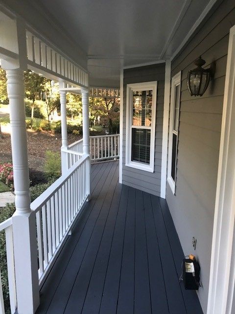 A porch with a white railing and a window