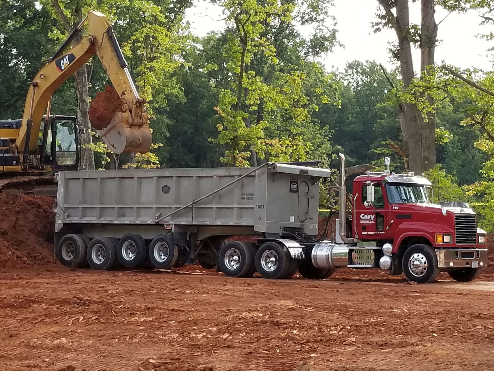 A man wearing gloves is driving a bulldozer on a construction site.