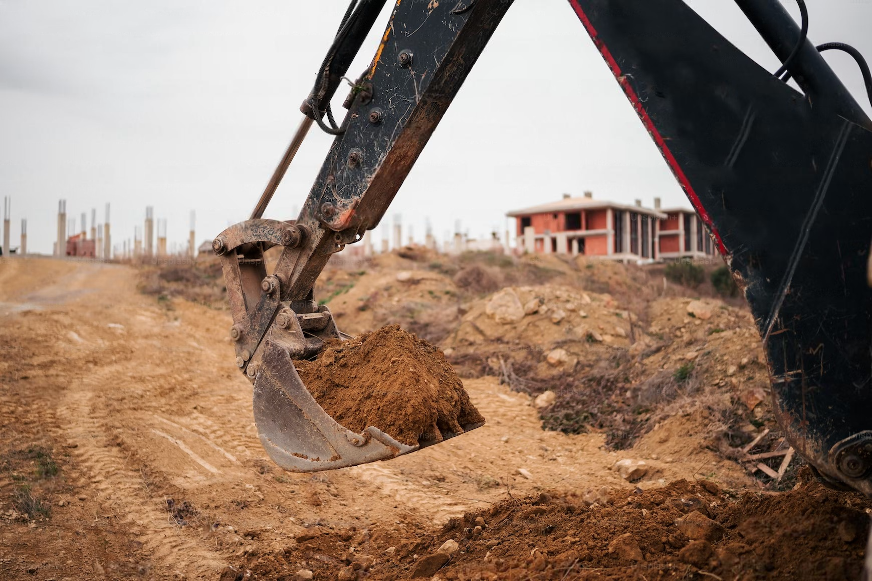 An excavator is digging a hole in the ground at a construction site.