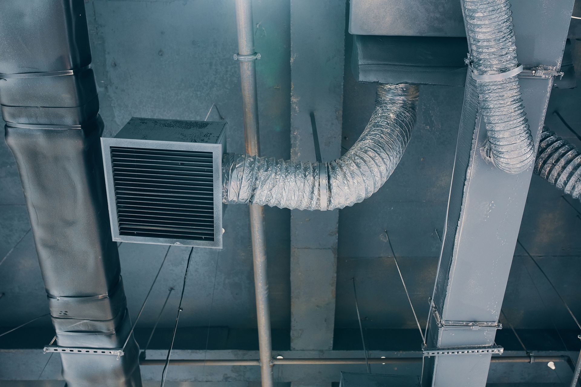 Ceiling with ventilation ducts, silver and gray, in an industrial setting.