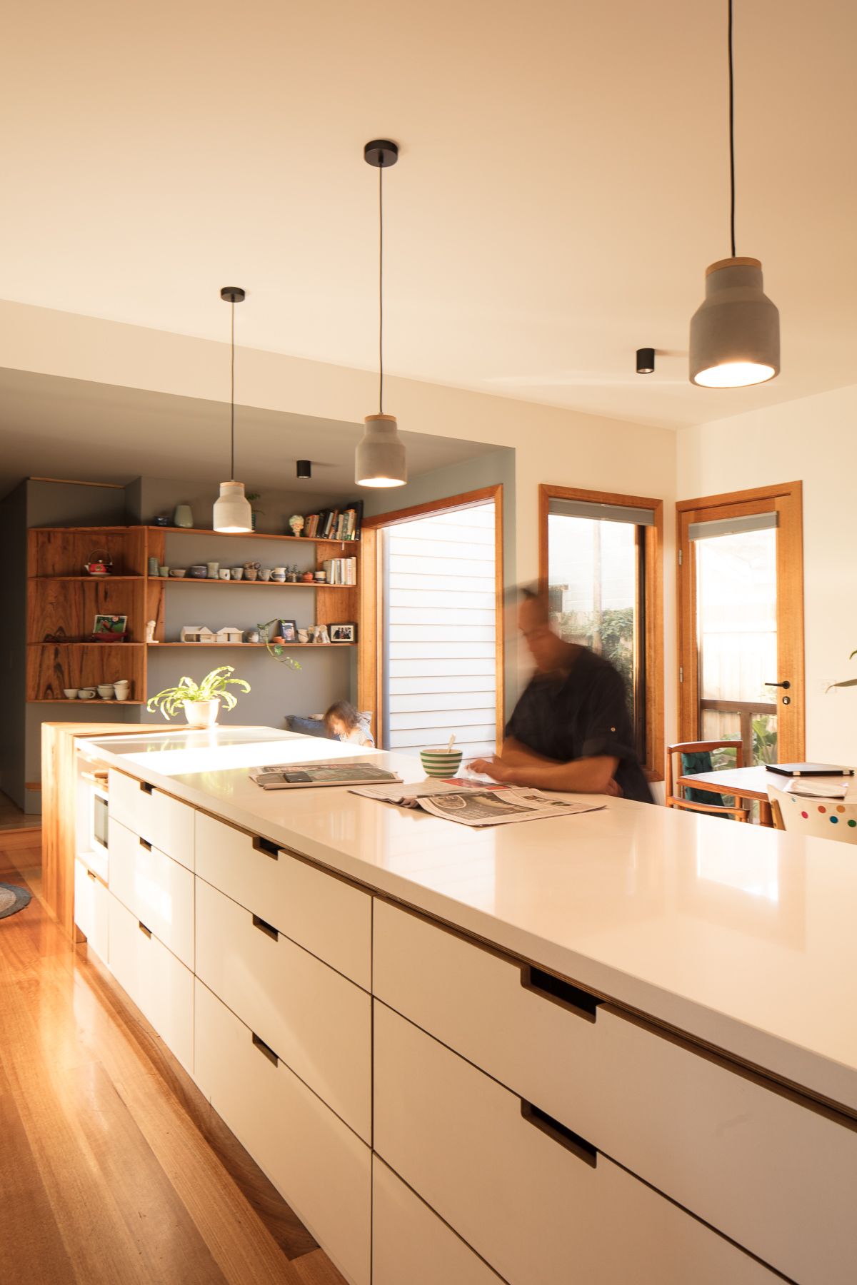 A man is standing at a counter in a kitchen.