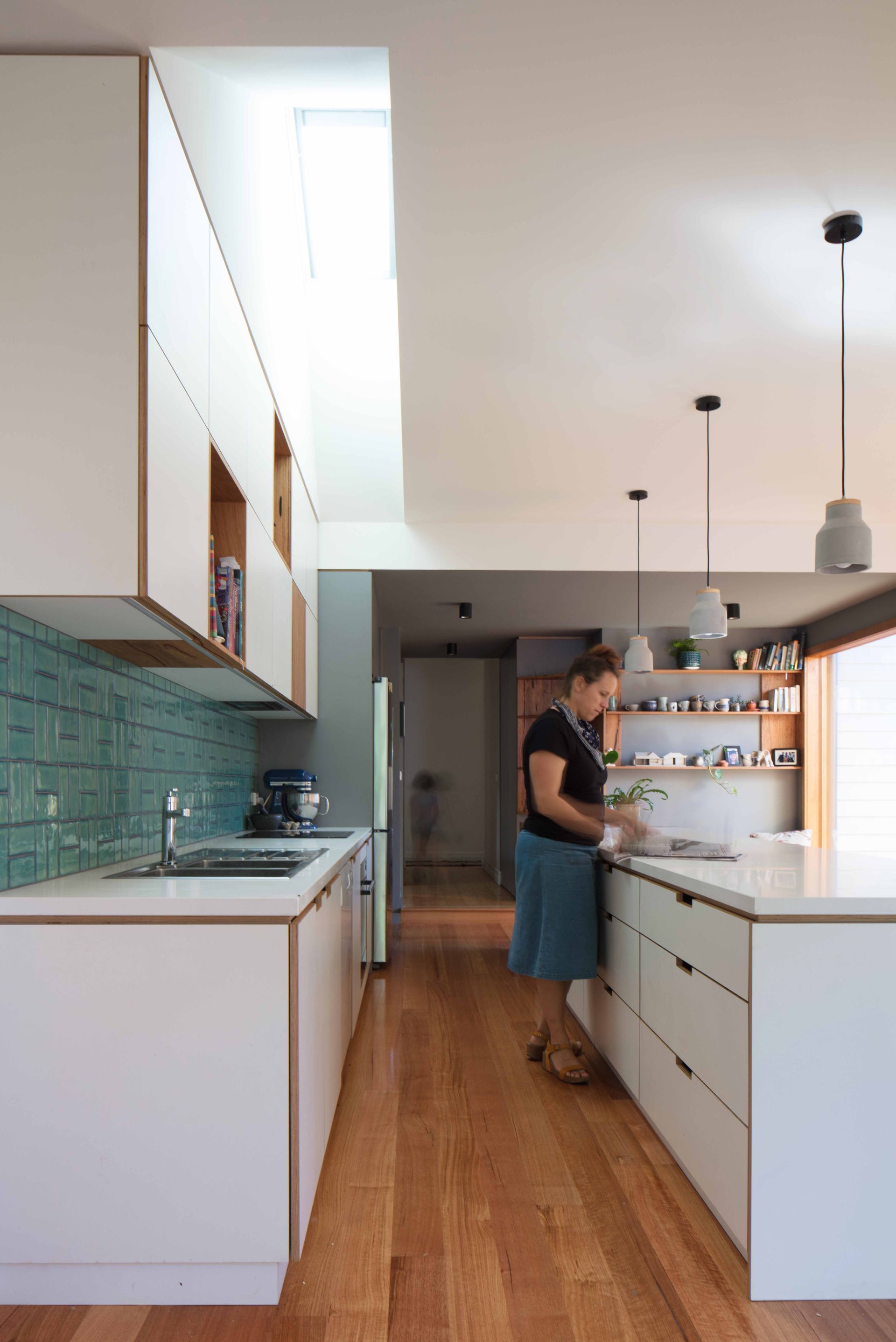 A woman is standing in a kitchen preparing food.