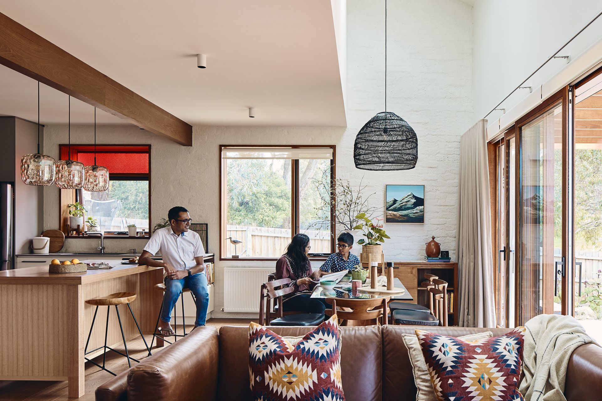 A family is sitting at a table in a living room.