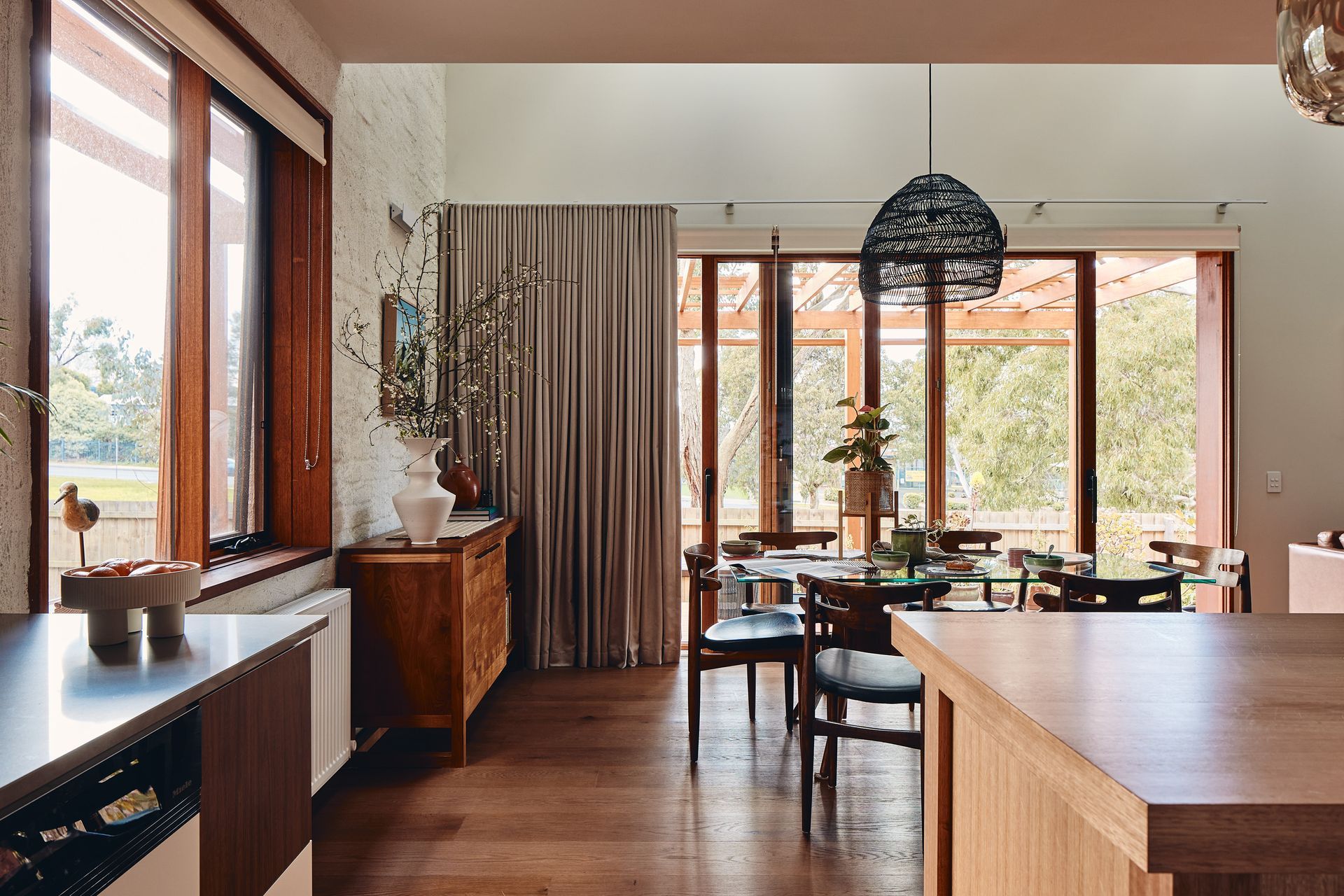 A kitchen with a dining room table and chairs and a large window.