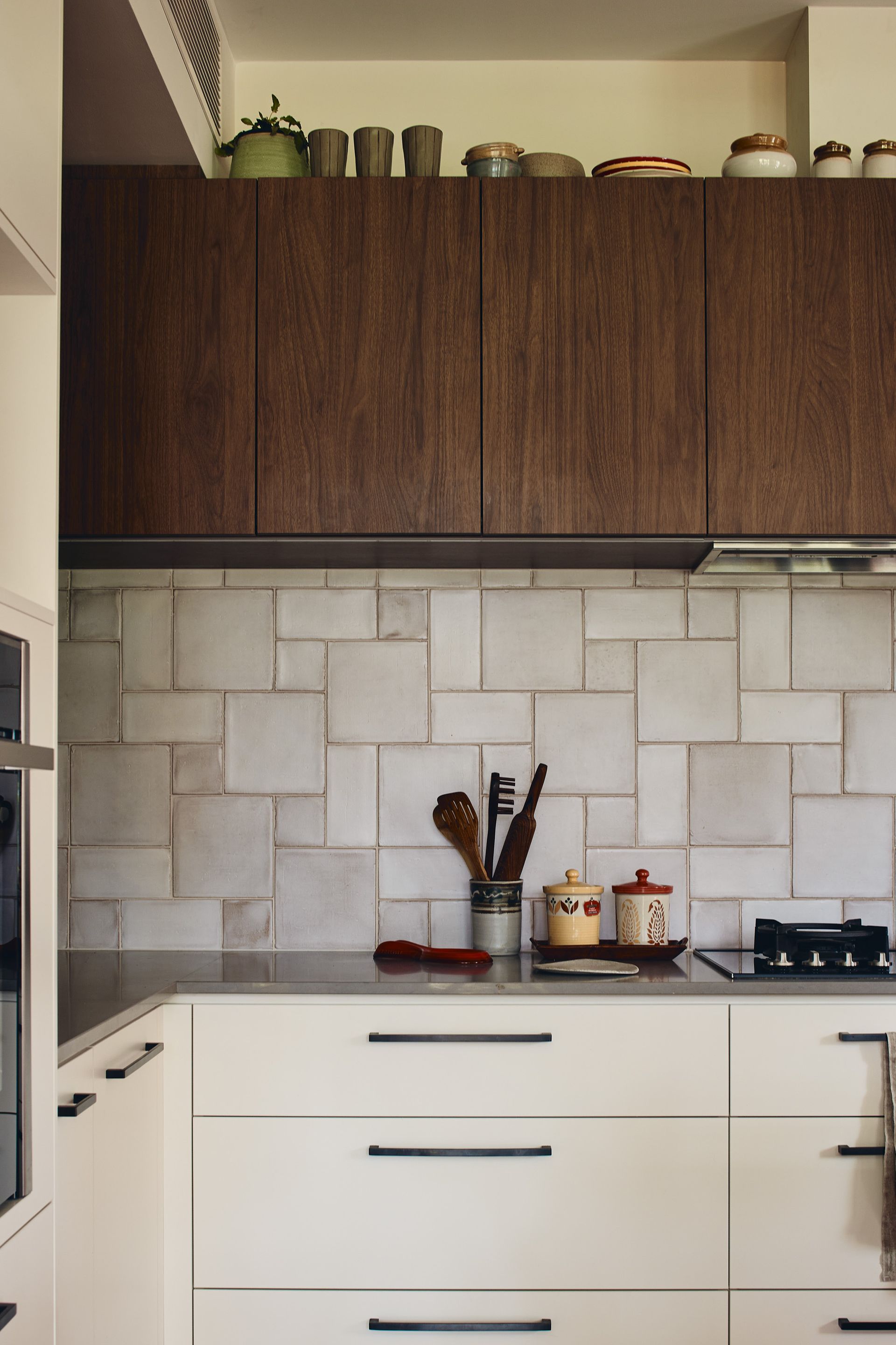 A kitchen with white cabinets and wooden cabinets