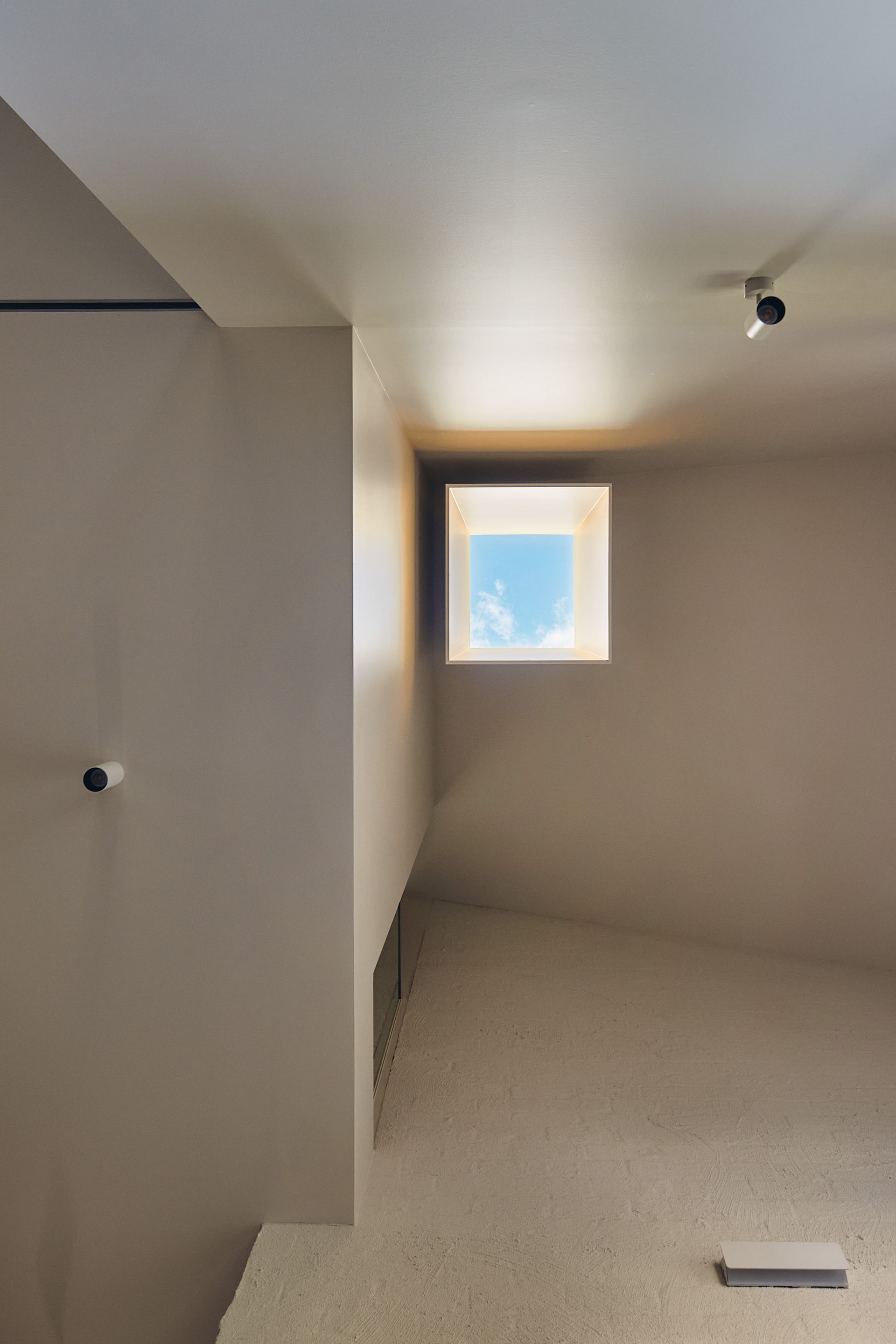 There is a square window in the corner of the room.