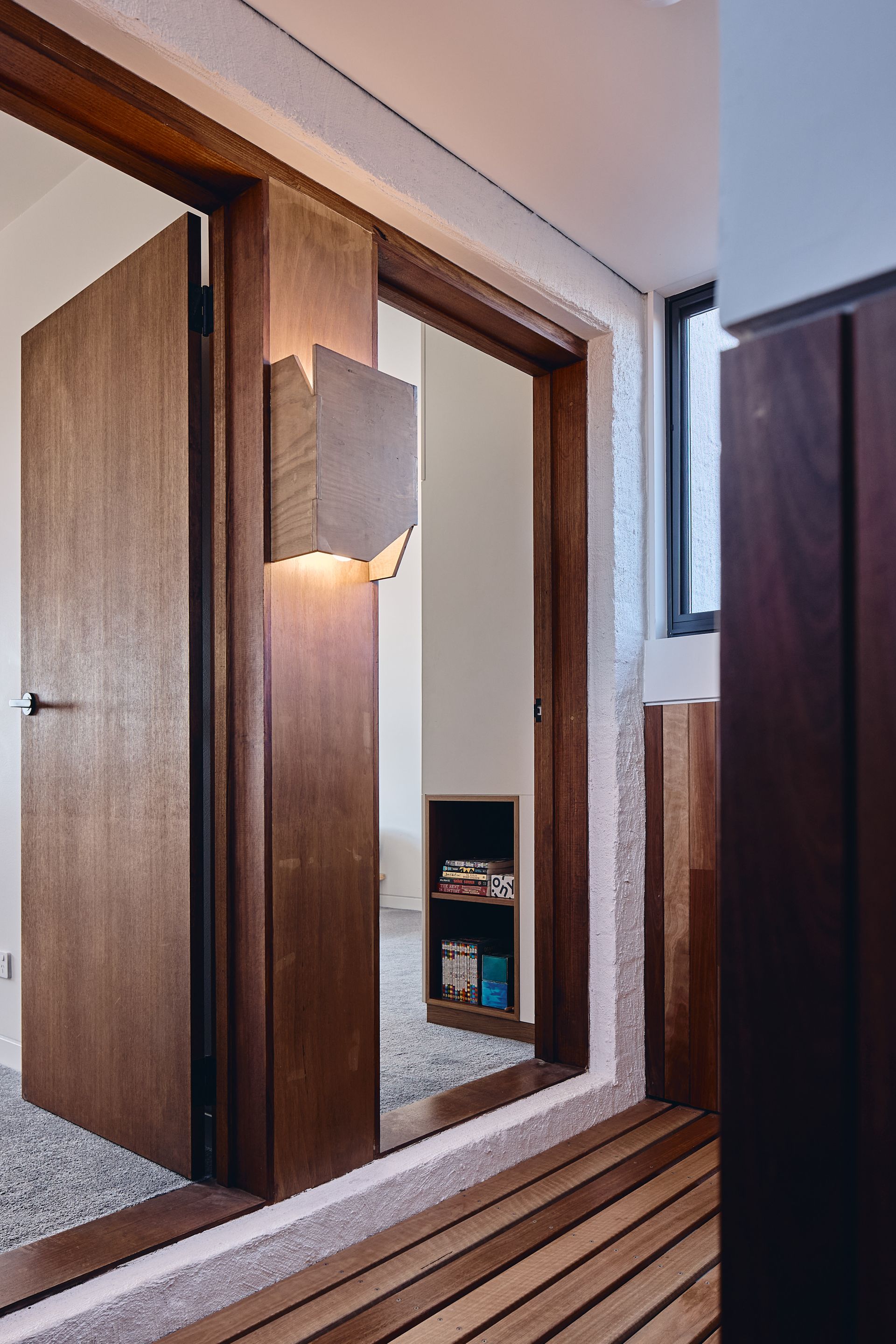 A wooden door is open to a room with a window.