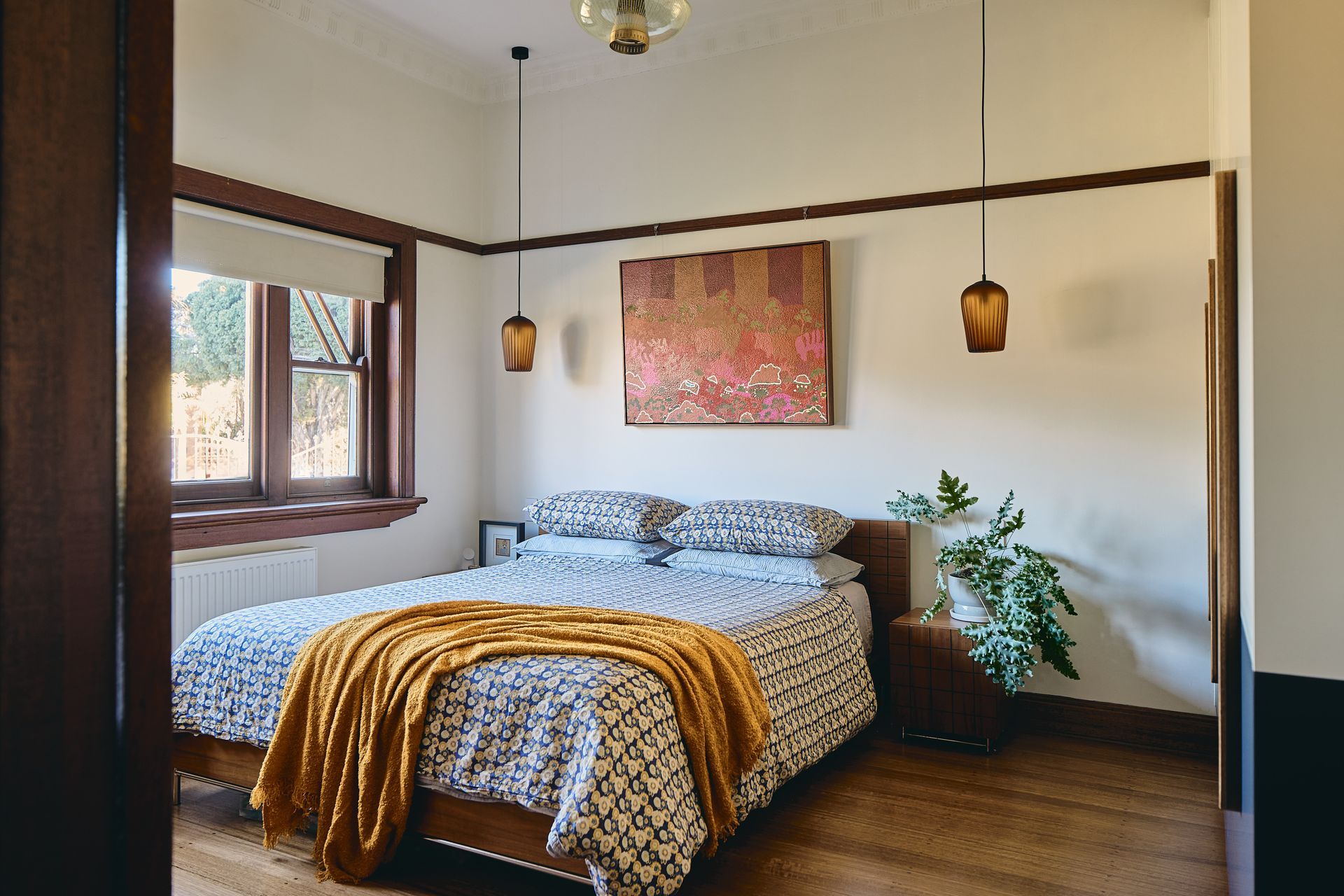 A bedroom with a bed and a painting on the wall.