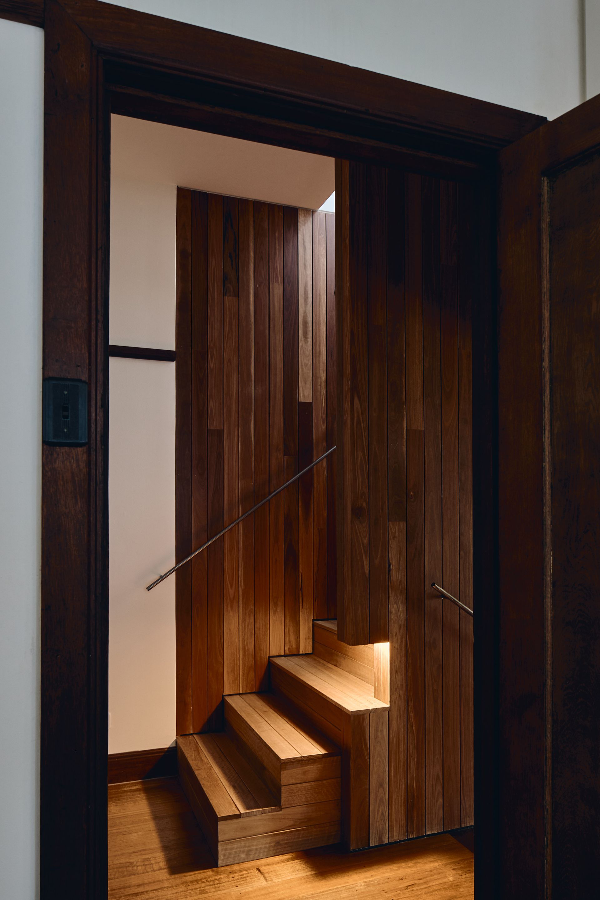 A wooden staircase is visible through a doorway