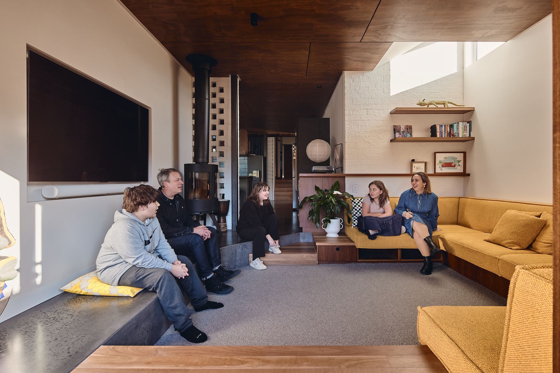 A family is sitting on a couch in a living room.