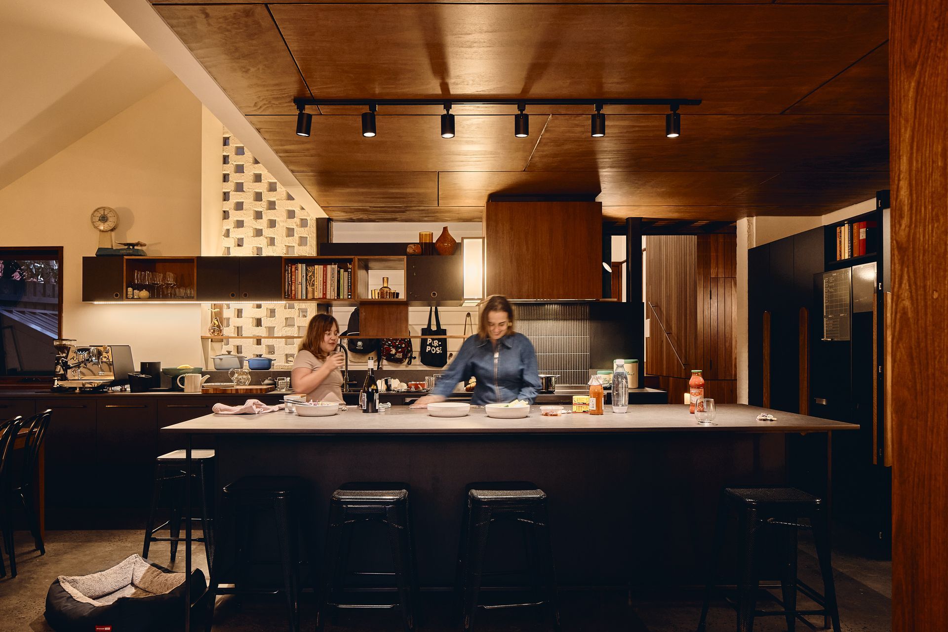 A man and a woman are sitting at a table in a kitchen.