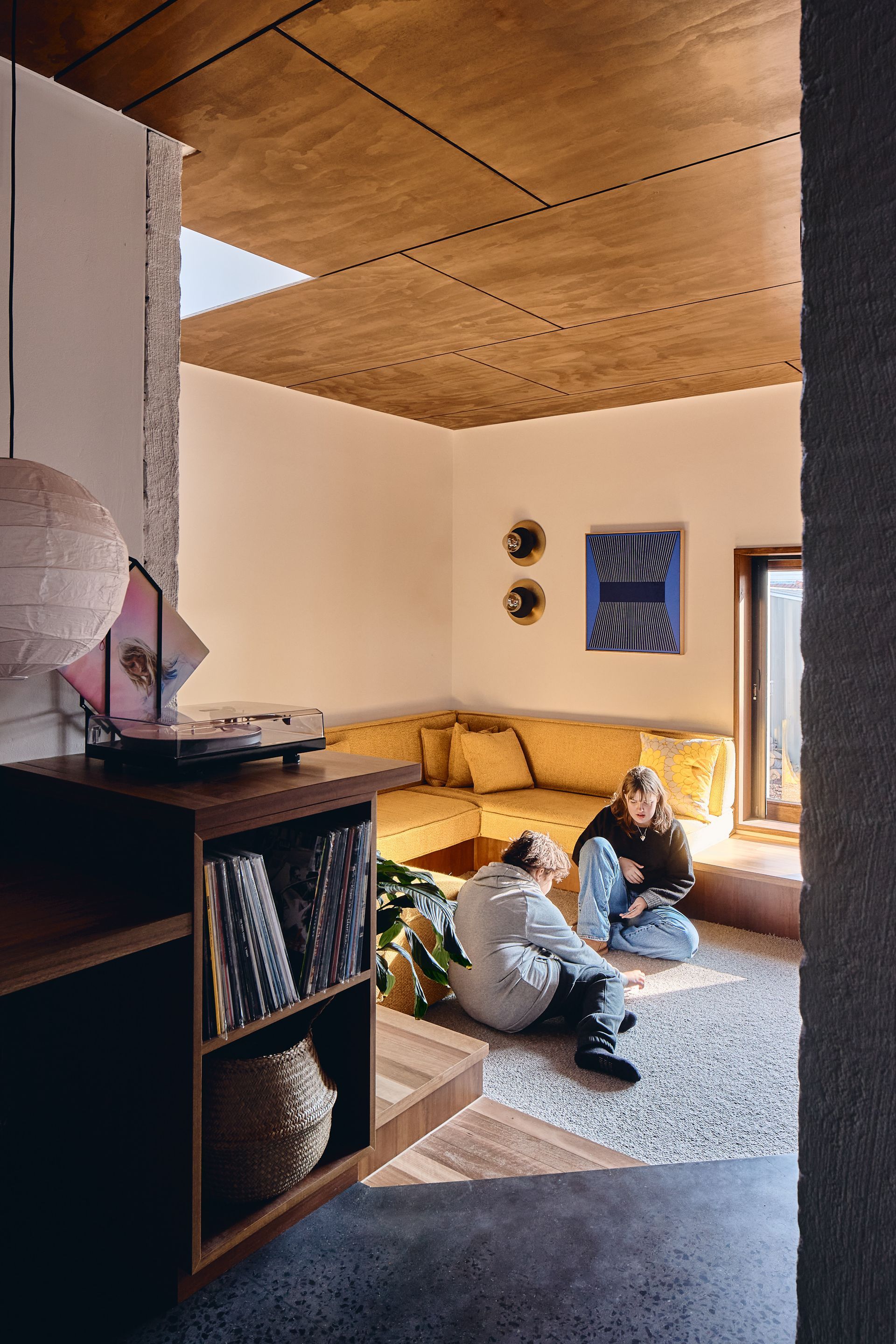 Two people are sitting on the floor in a living room.