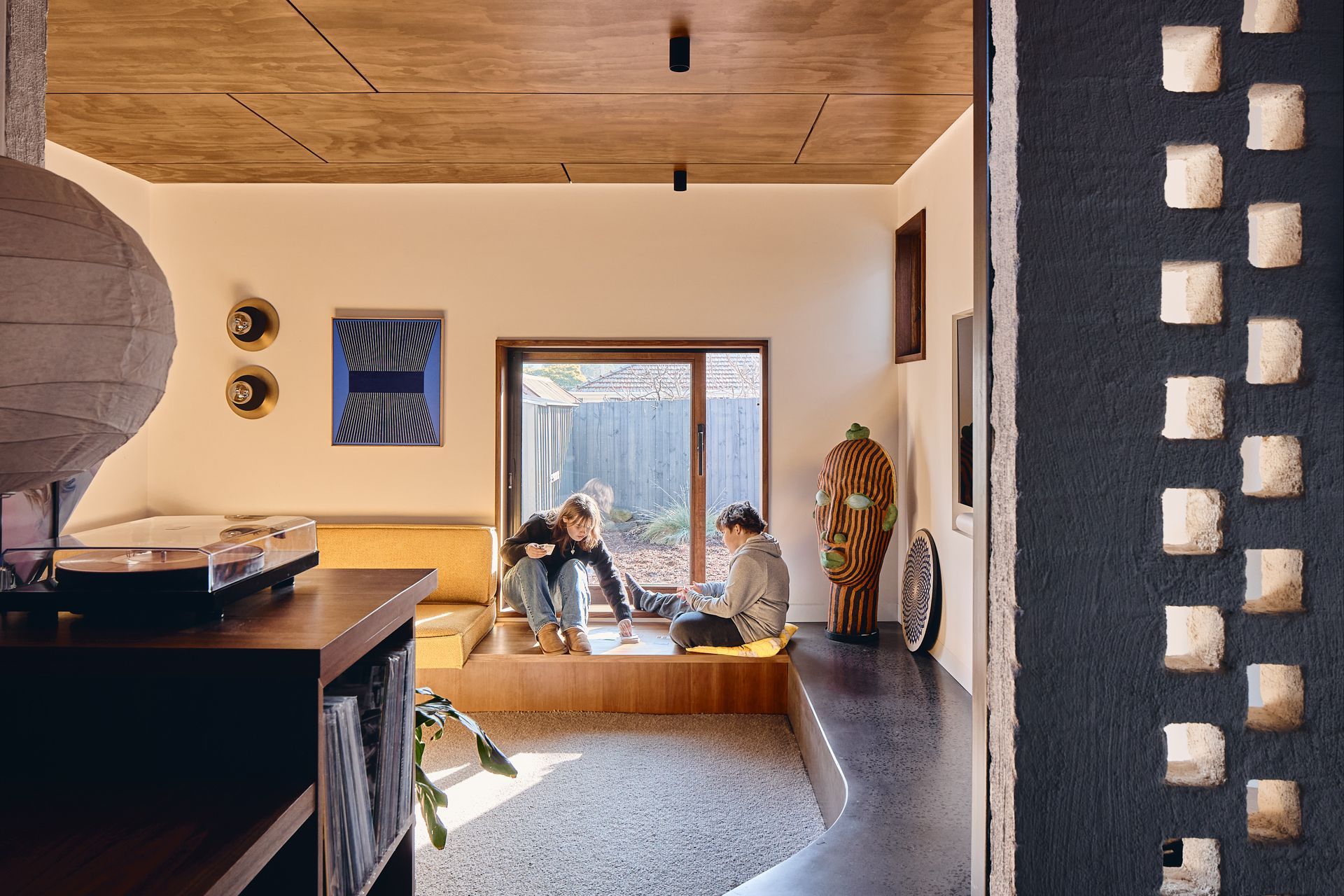 A couple of people are sitting on a couch in a living room.