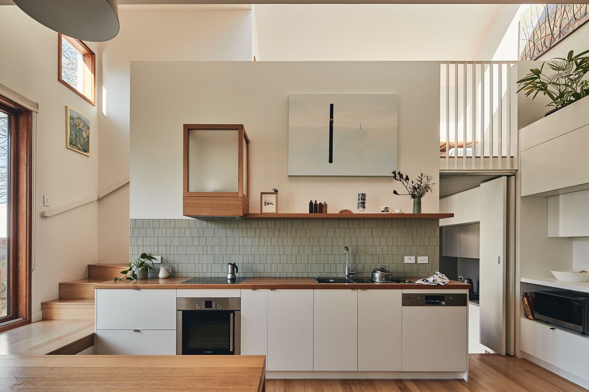 A kitchen with white cabinets and wooden counter tops.