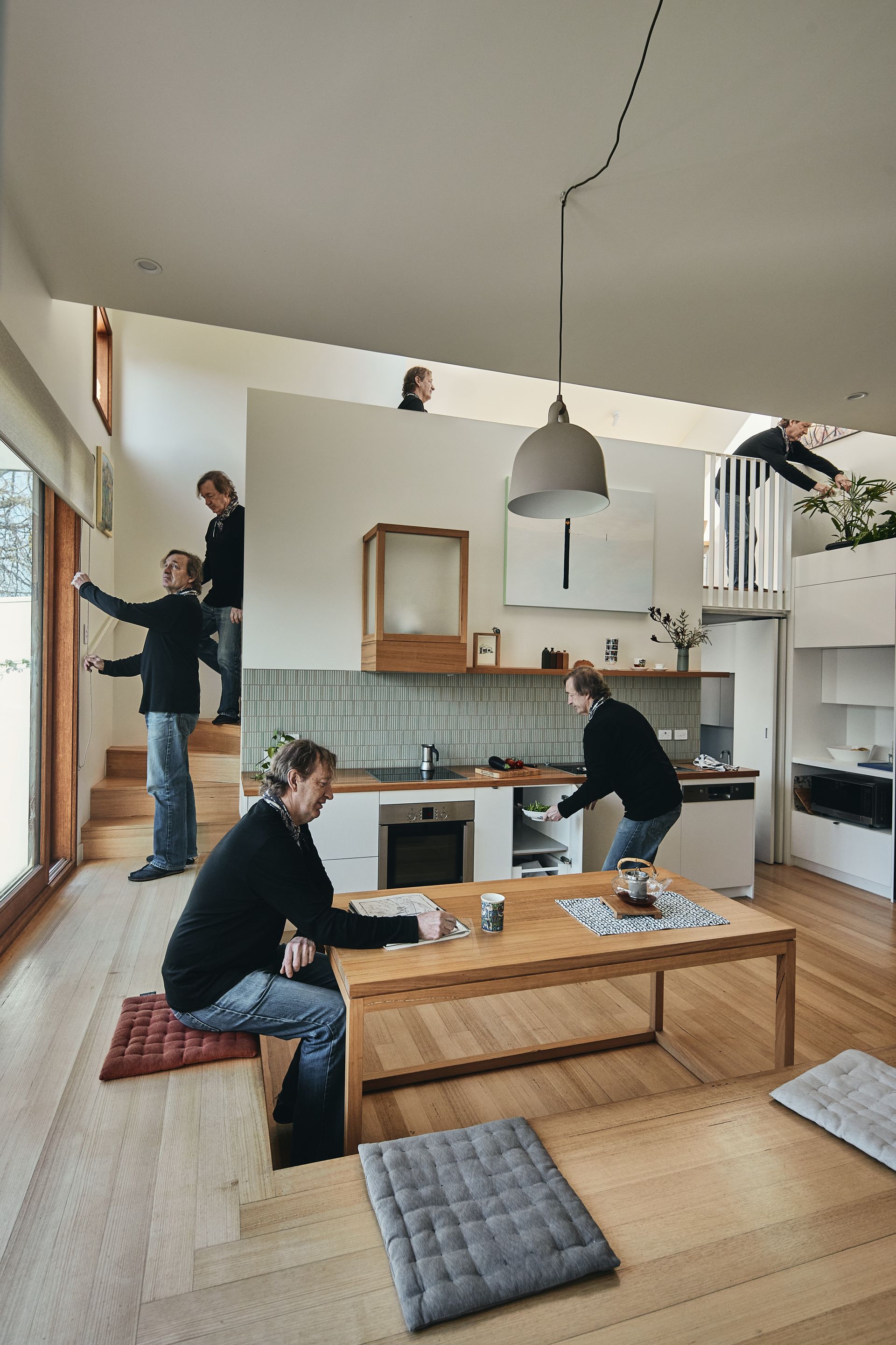A group of people are sitting at a table in a kitchen.
