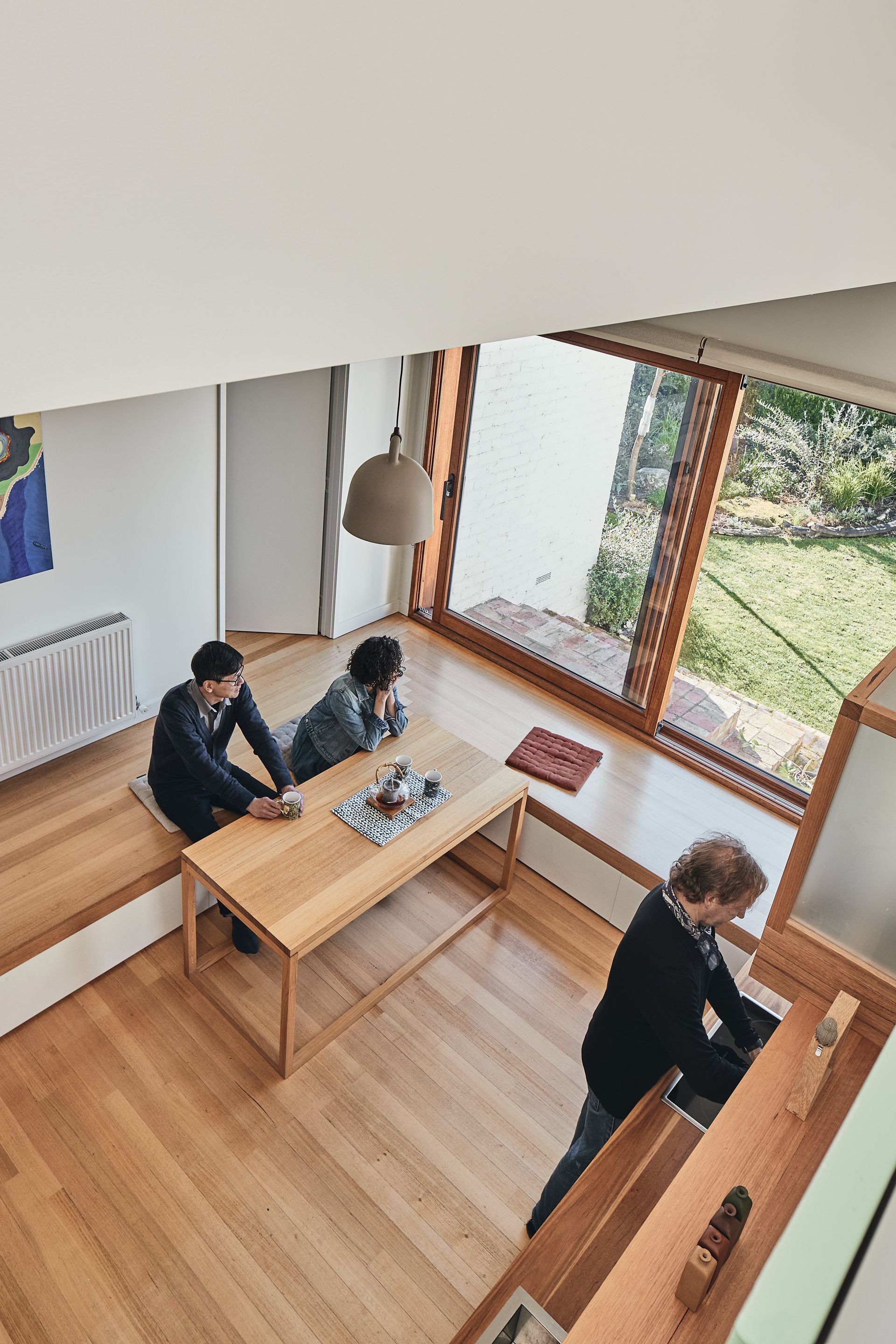 A group of people are sitting at a table in a kitchen.