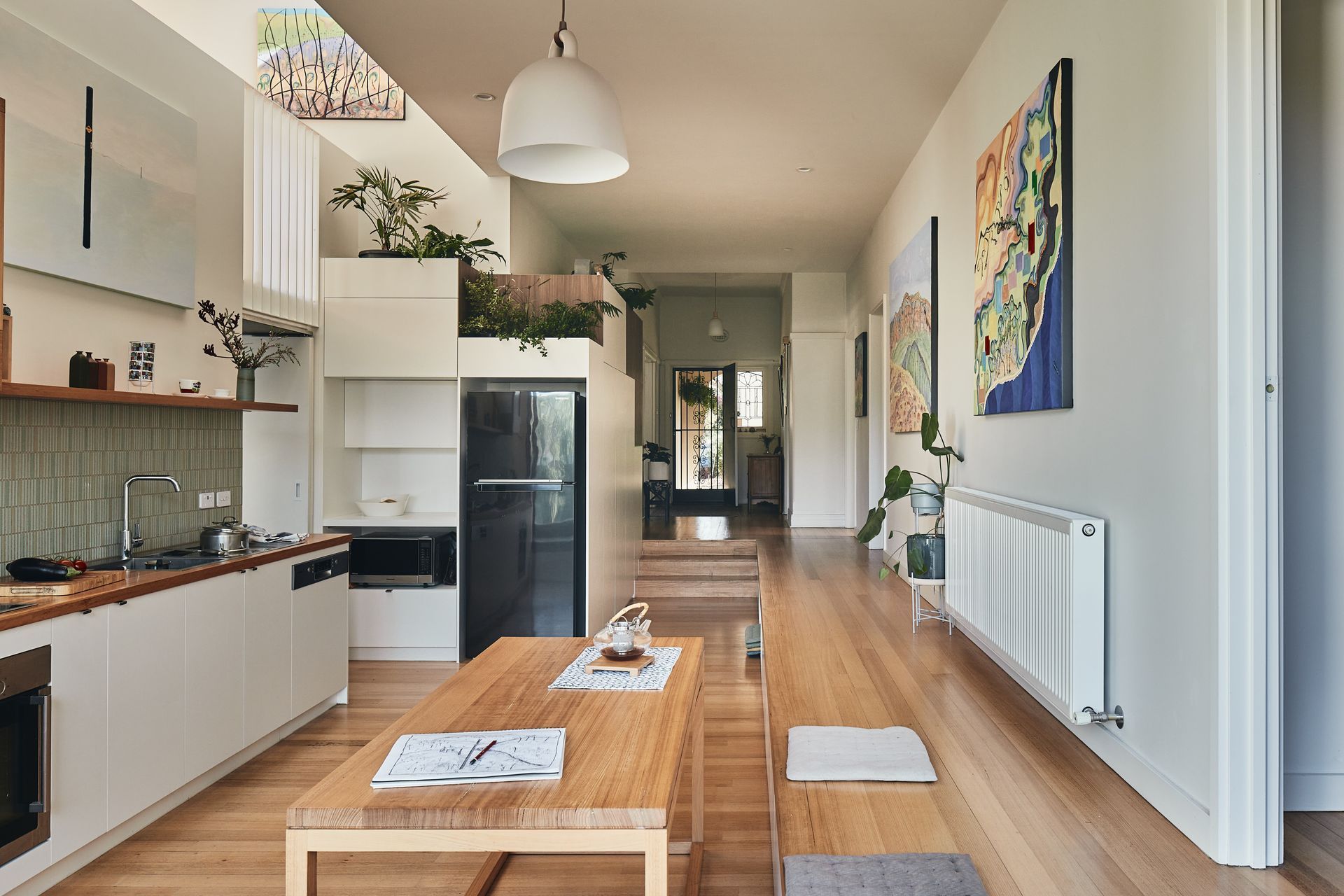 A kitchen with a table and a refrigerator in it