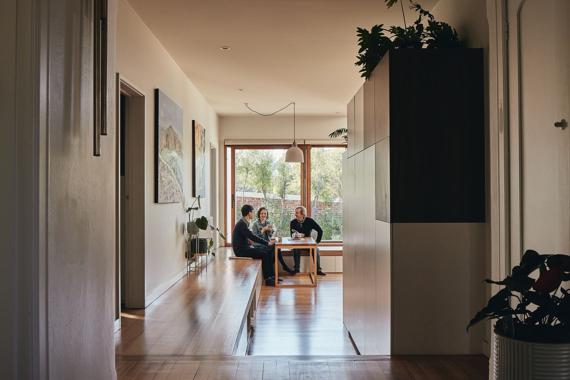 A couple of people are sitting at a table in a living room.