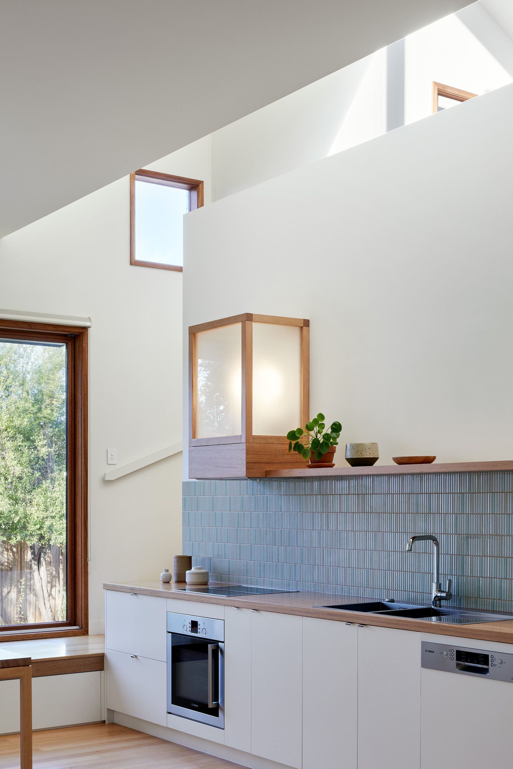 A kitchen with white cabinets and a large window