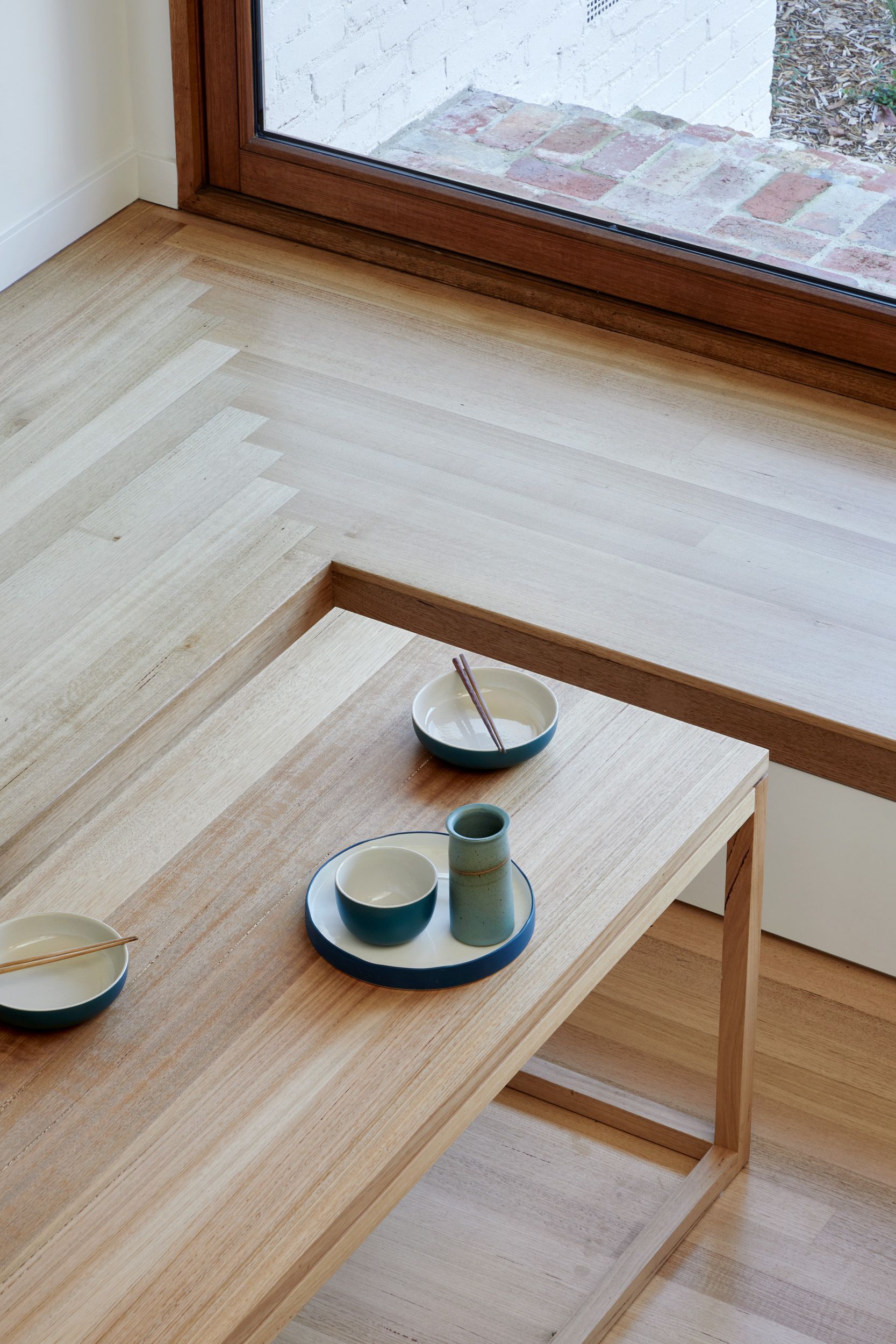 A wooden table with two bowls and a cup on it
