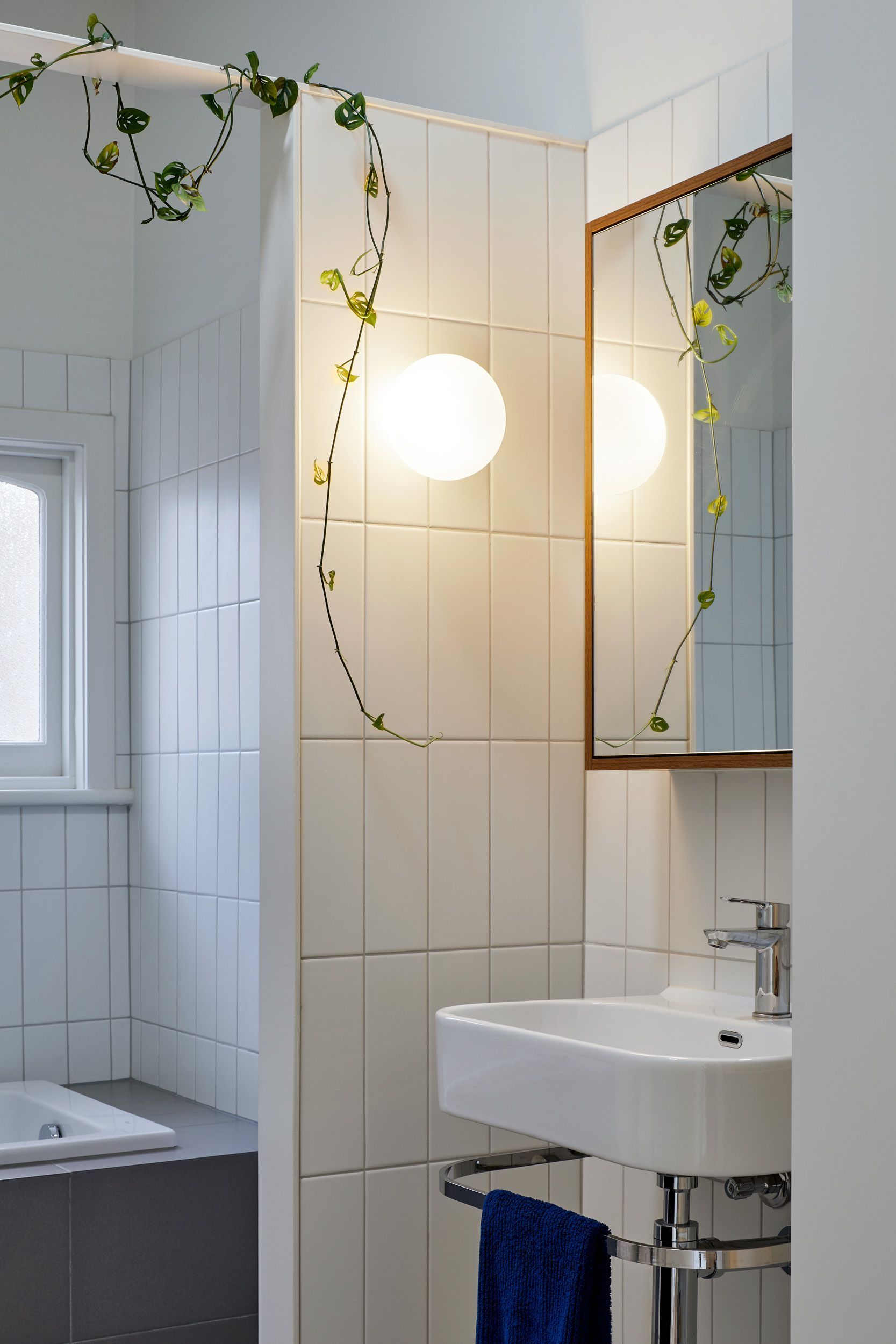 A bathroom with a sink , mirror and shower curtain.