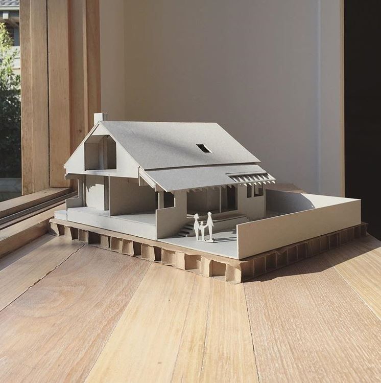 A model of a house is sitting on a wooden table