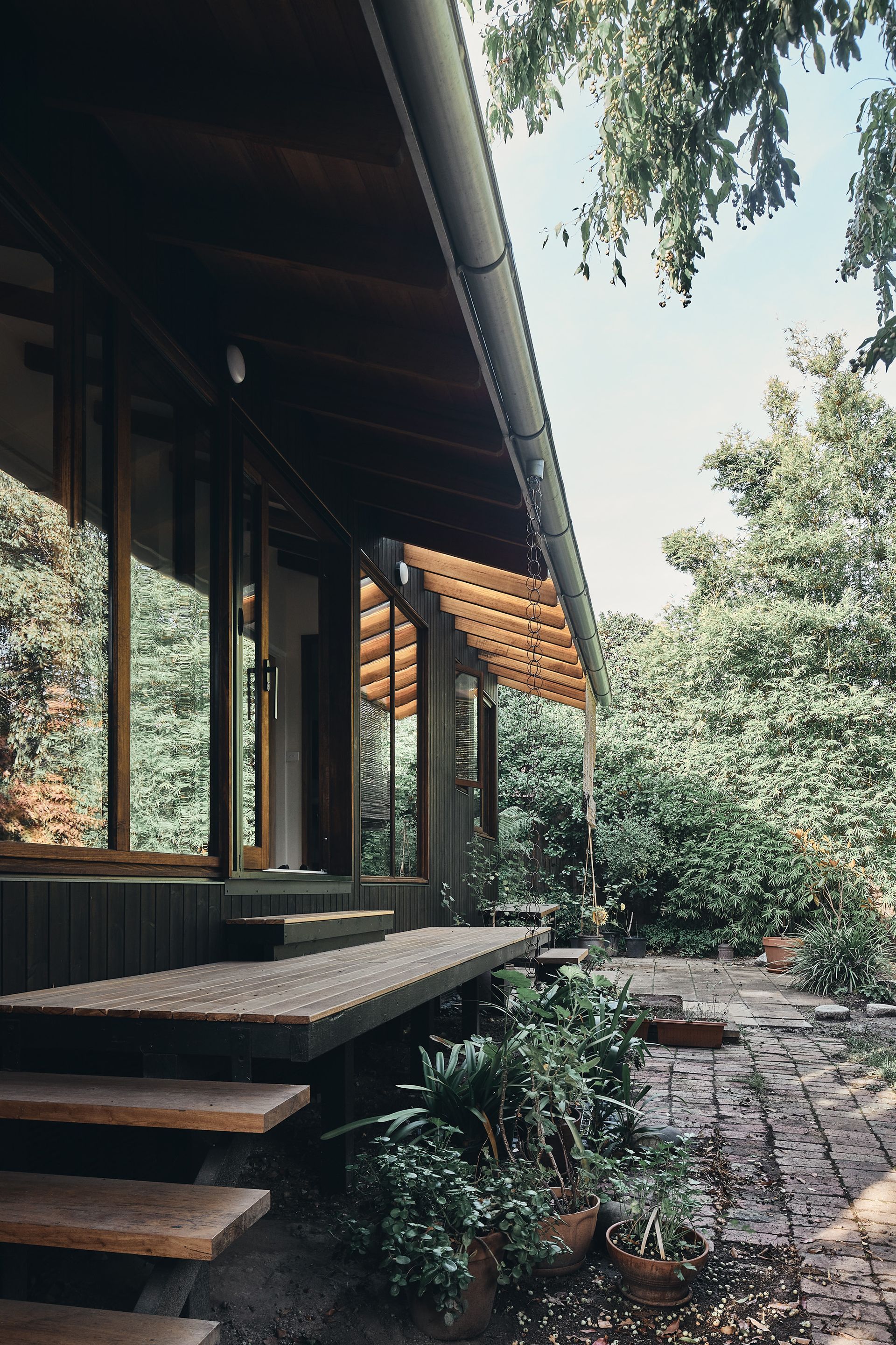 A house with a porch and stairs leading up to it surrounded by trees.