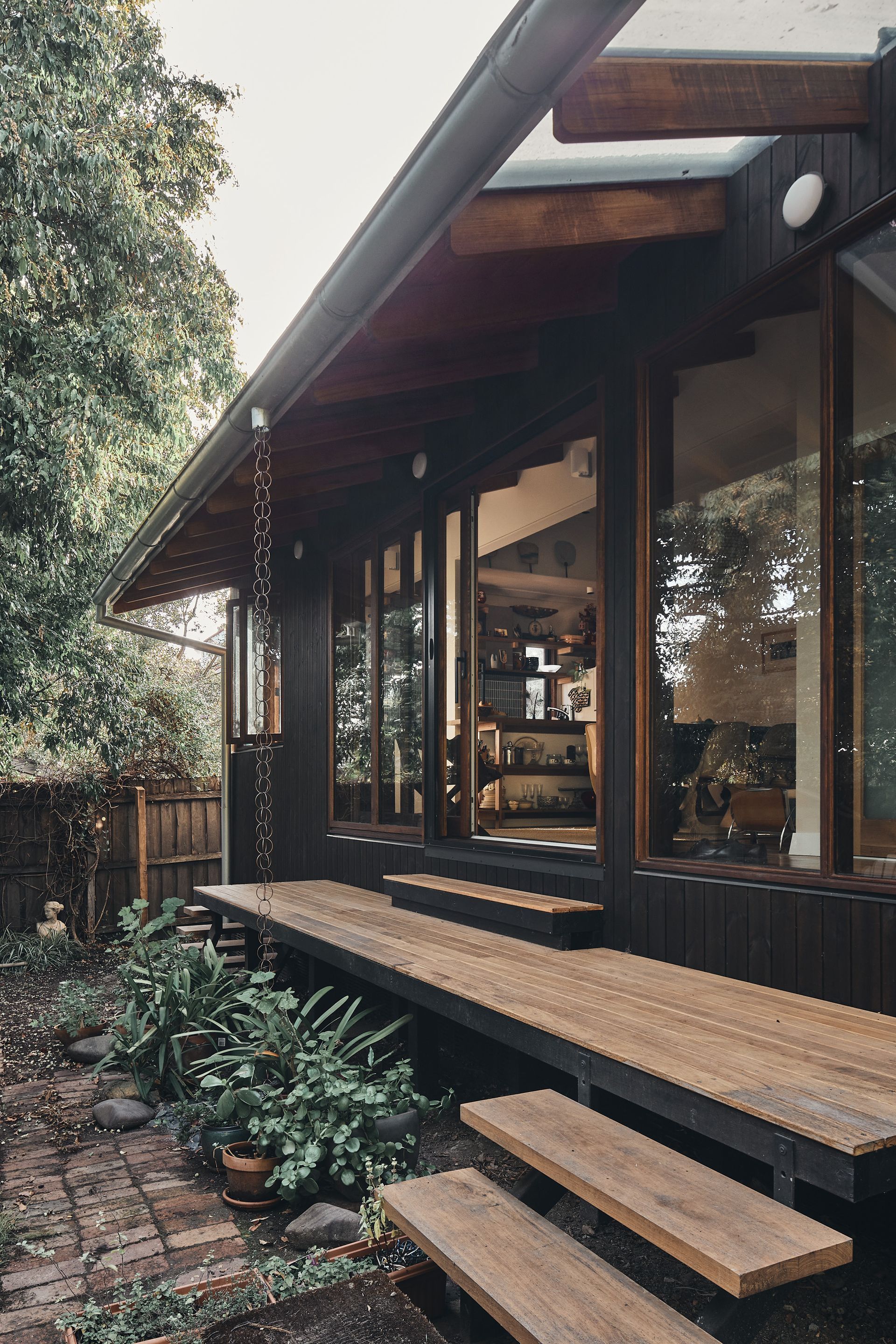 A house with a wooden deck and stairs leading to it.