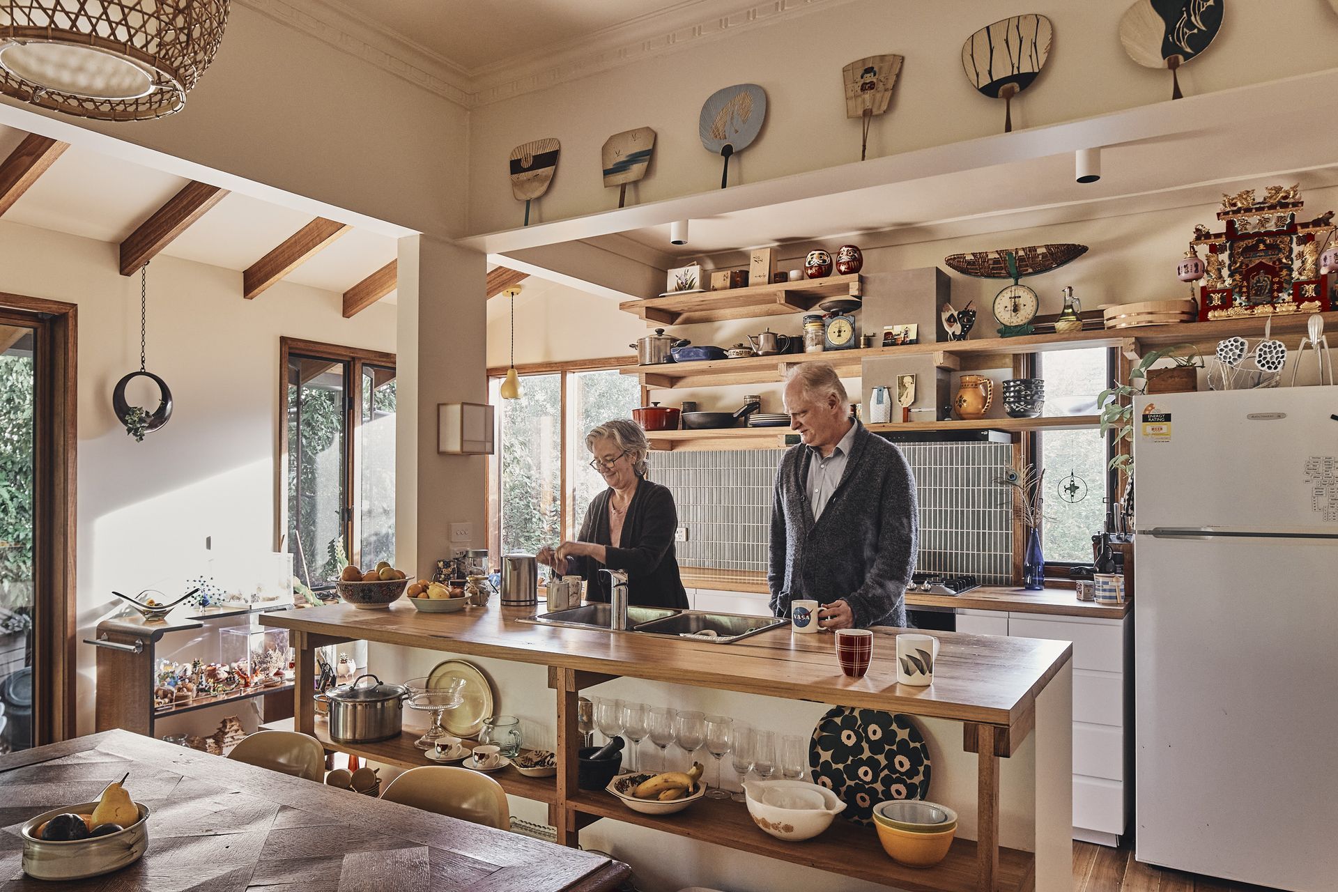 A man and a woman are standing in a kitchen preparing food.