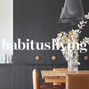 A dining room with a table and chairs and a vase of flowers.