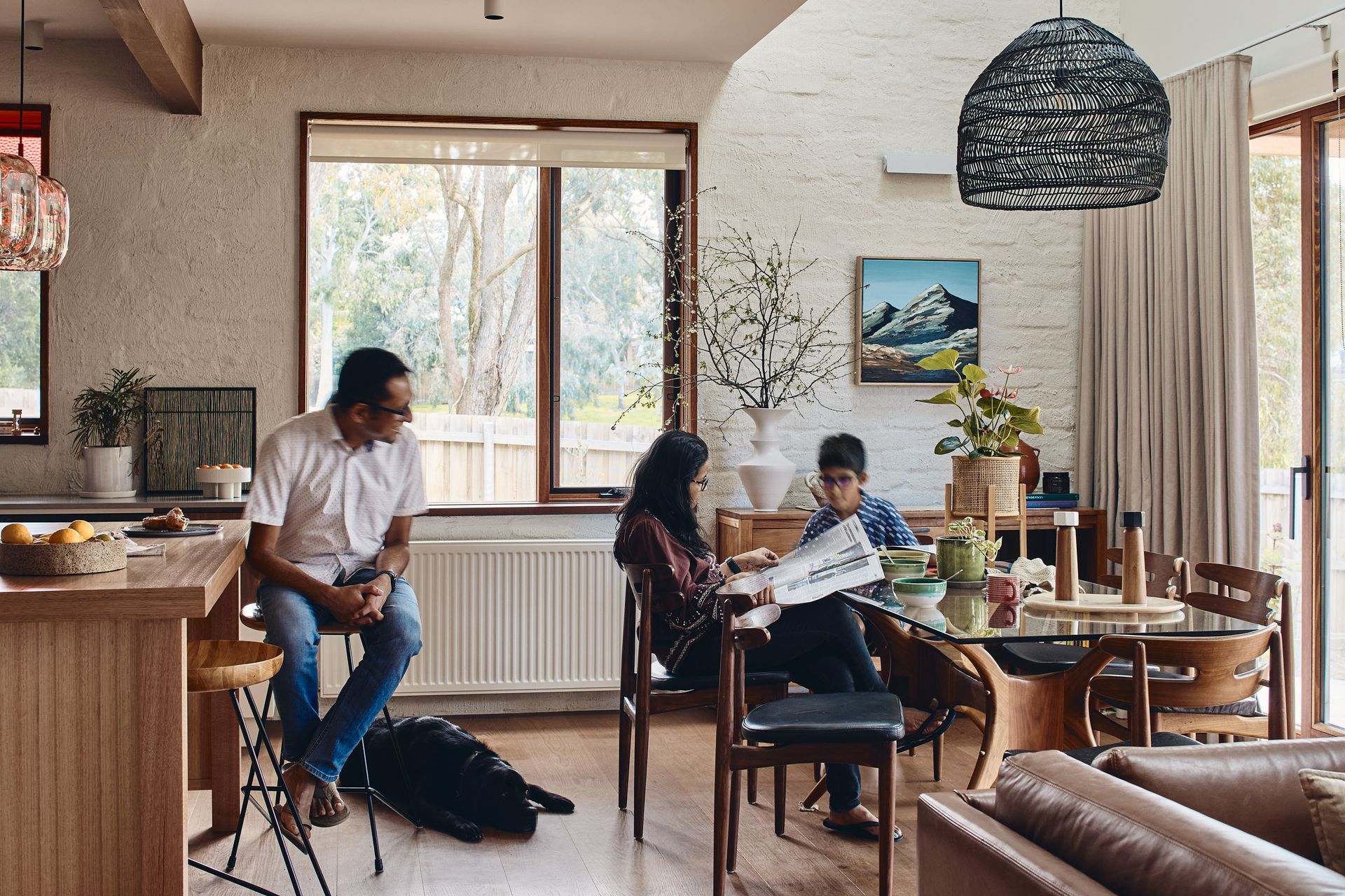 A group of people are sitting at a table in a living room.