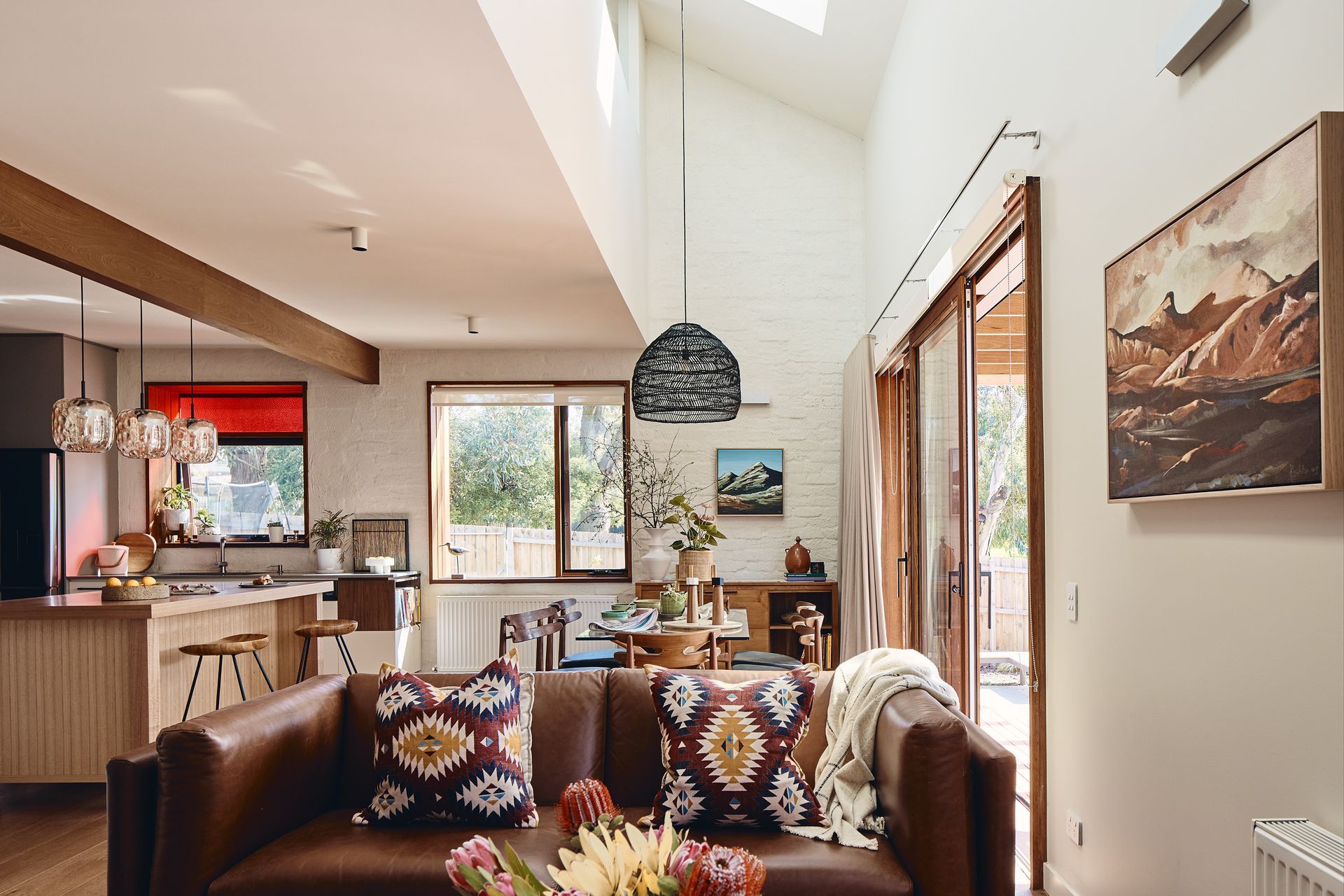 A living room with a brown couch and a painting on the wall