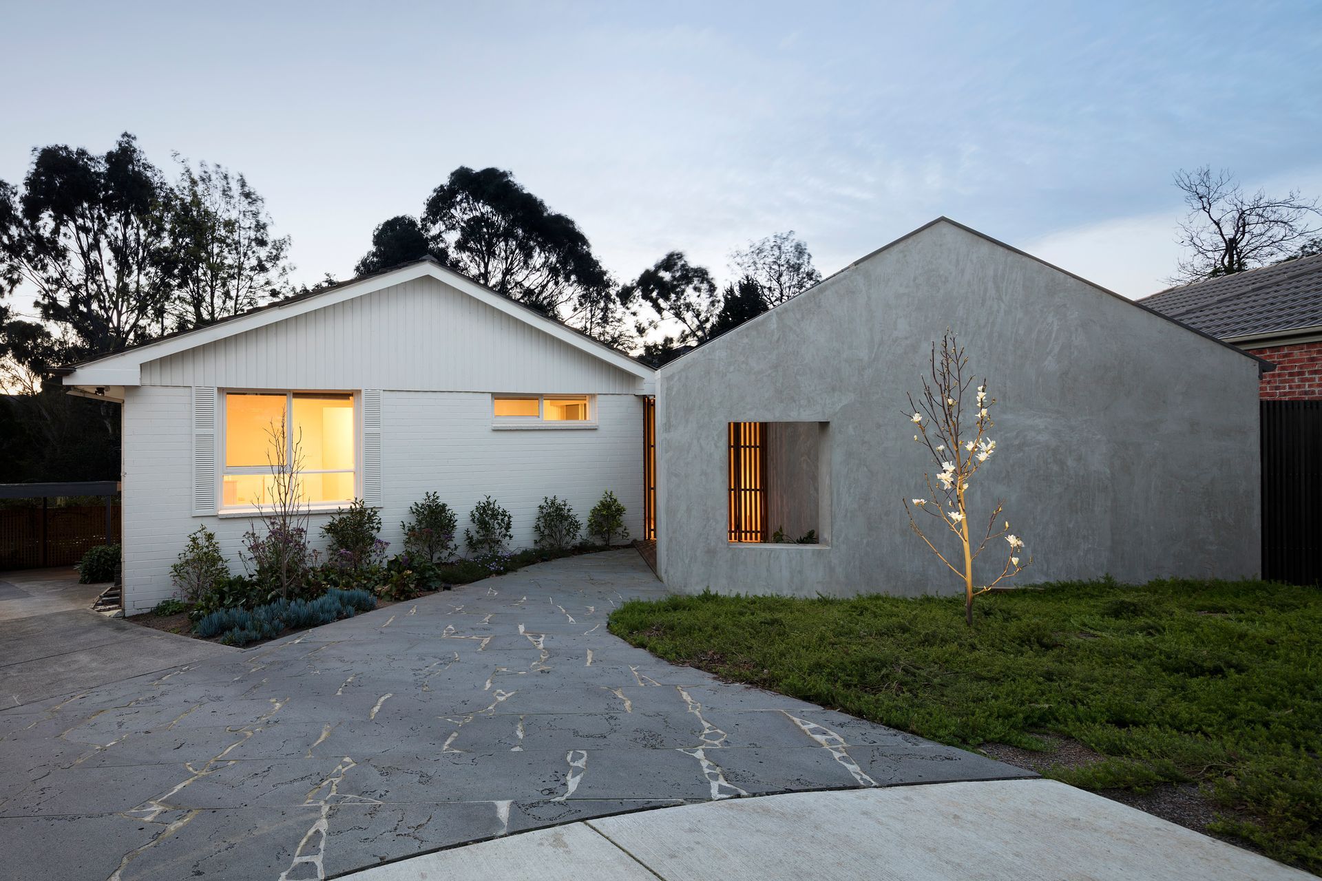 A white house with a concrete driveway in front of it