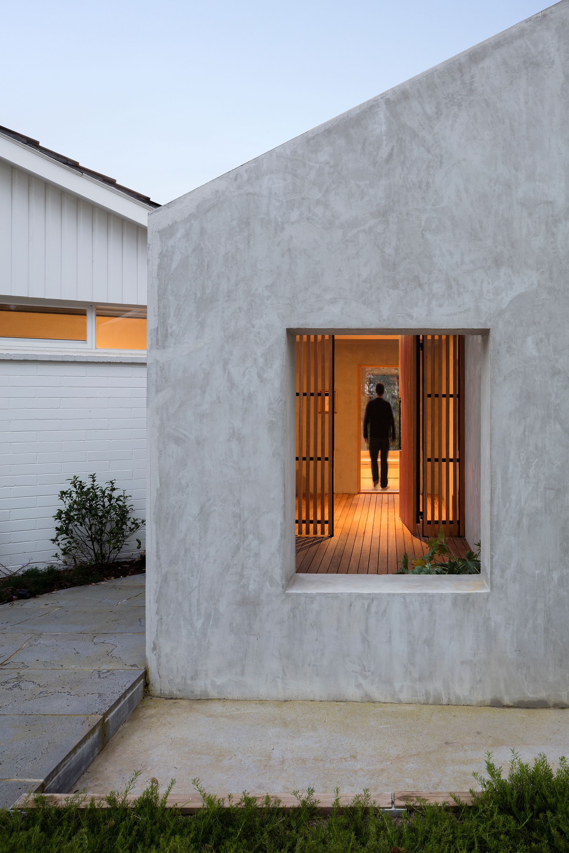 A man is standing in front of a window in a house.