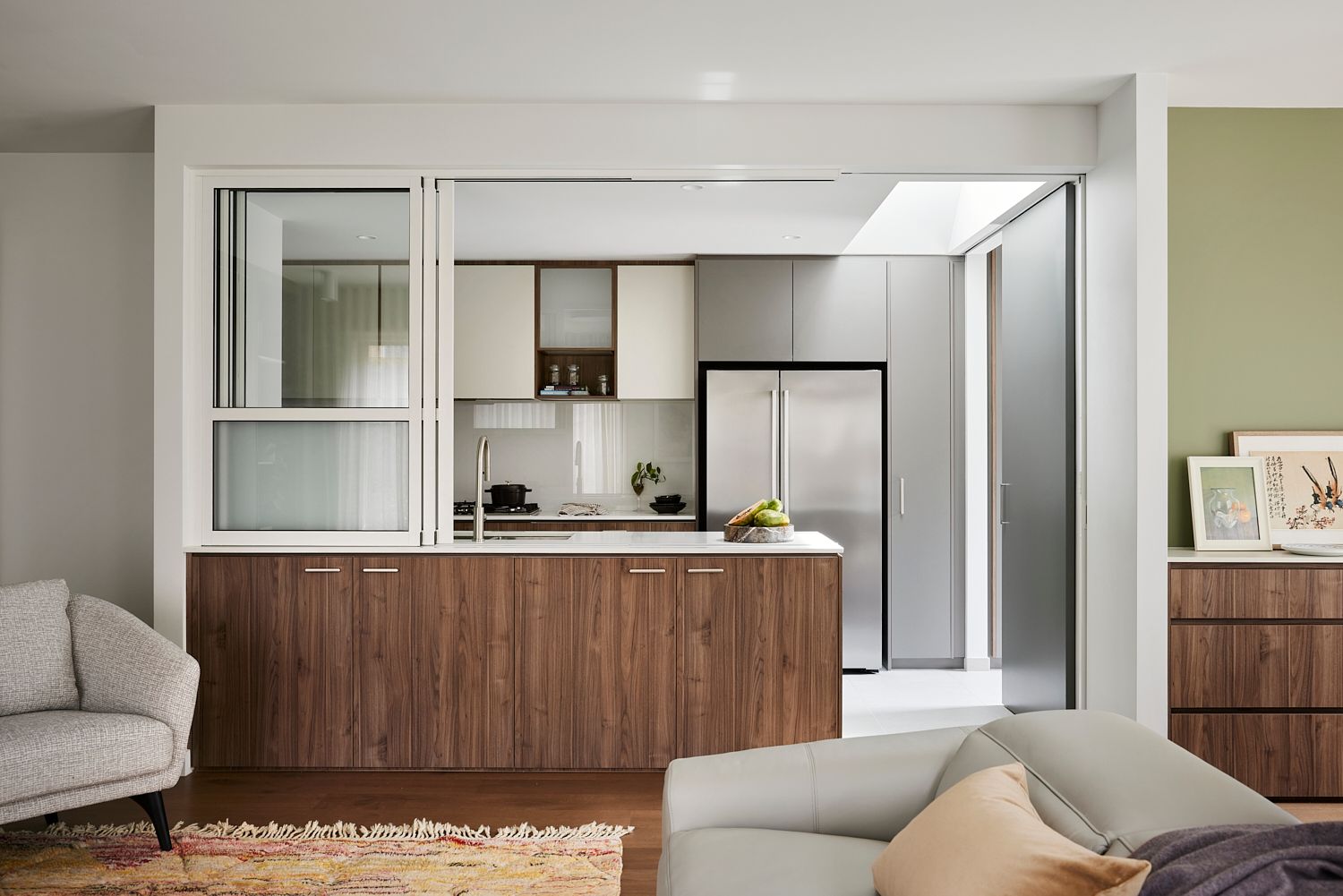 A living room with a couch , chair , and kitchen.