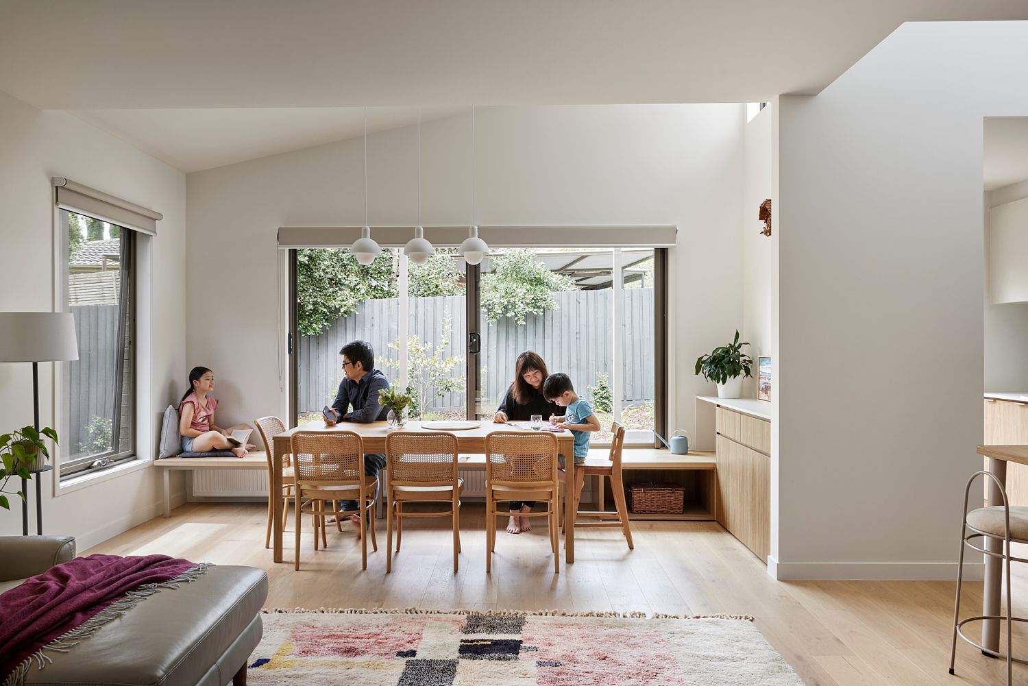A family is sitting at a table in a living room.