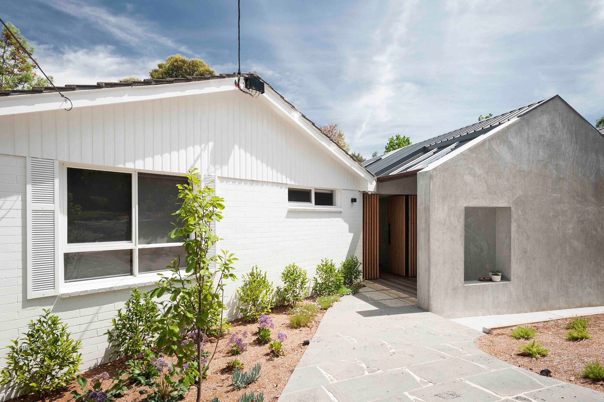A white house with a concrete walkway leading to it